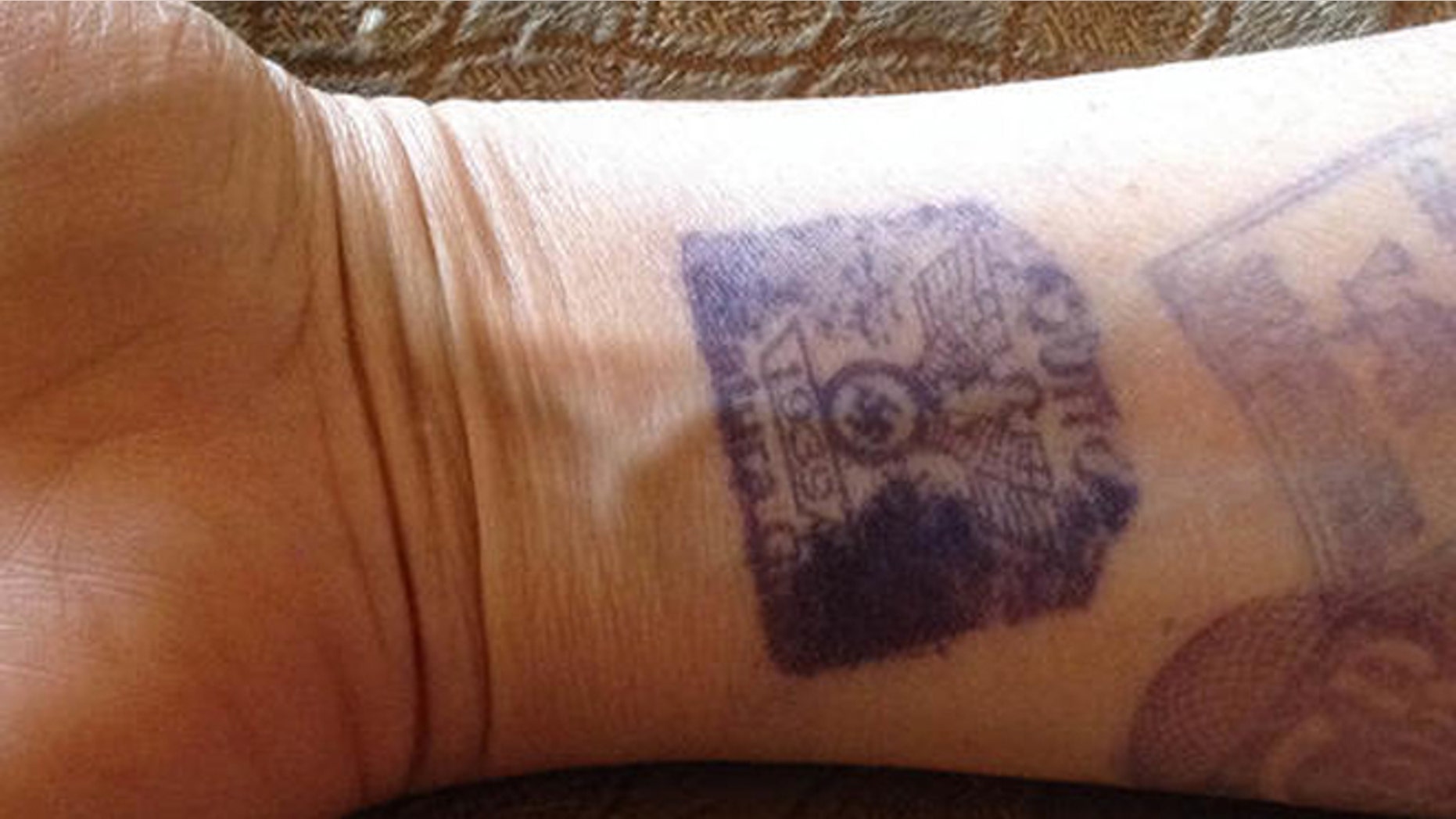 ALTERNATE CROP- In this Sept. 3, 2016, cell phone photo, provided by Maria Isabel Bonilla, shows her arm with prison visitors stamps, one featuring a Nazi Swastika, in Quito, Ecuador. Security guards at the prison were marking visitors with the stamps featuring the emblem of the Nazi Party with an eagle atop a Swastika and the year 1939. Bonilla who's husband is an inmate at the prison posted the photo on twitter causing an immediate uproar, with Ecuadors government immediately condemning the practice. (Maria Isabel Bonilla via AP)