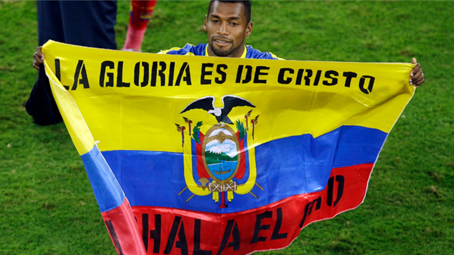 June 20, 2014: Ecuador's Gabriel Achilier holds a Ecudorian flag with the writing 'The glory is for Christ' after winning 2-1 during the group E World Cup soccer match between Honduras and Ecuador at the Arena da Baixada in Curitiba, Brazil.