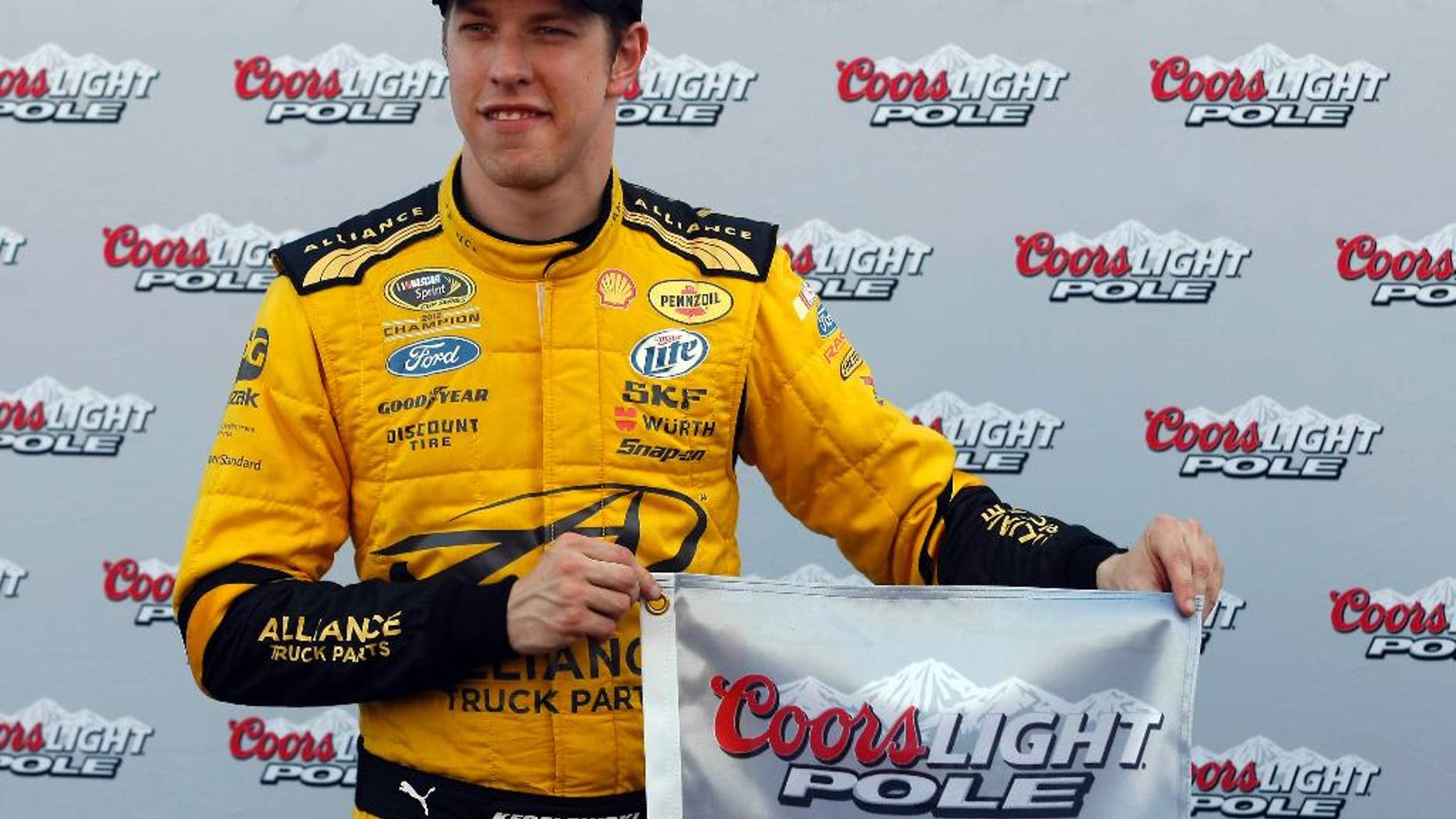 Brad Keselowski holds the flag after winning the pole for Sunday's NASCAR Sprint Cup Series auto race, Friday, Feb. 28, 2014, in Avondale, Ariz. (AP Photo/Rick Scuteri)