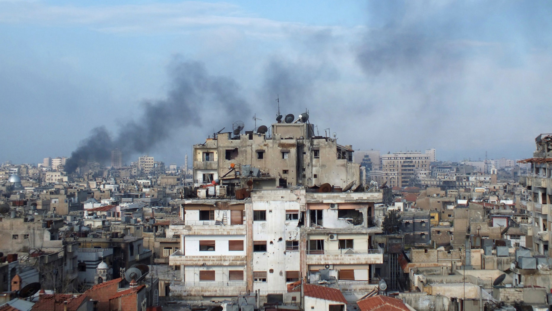 Smoke rises from a building in the city of Homs, Syria, in this file photo from March 2013.