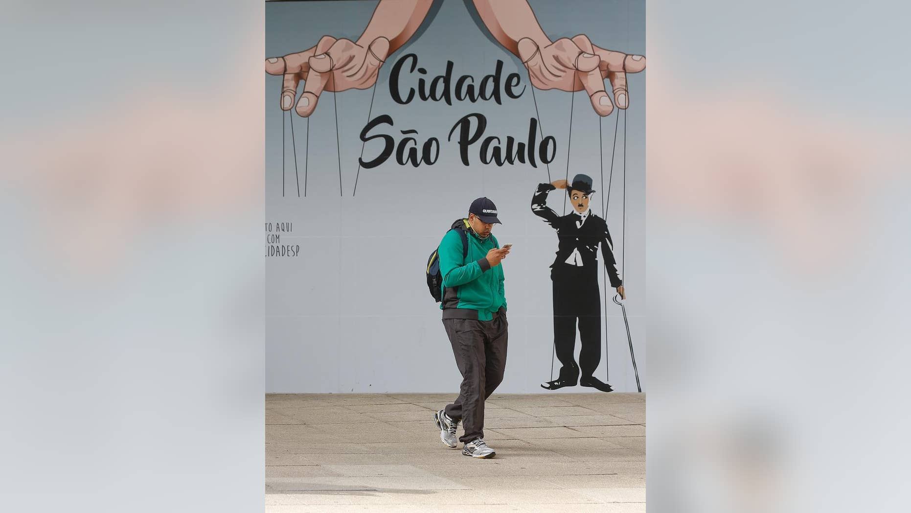 A man checks his cell phone outside a shopping mall in Sao Paulo, Brazil, Tuesday, July 19, 2016. A Brazilian judge has ordered the nationwide suspension of the instant messaging application WhatsApp because it won't help out in a police investigation. (AP Photo/Andre Penner)