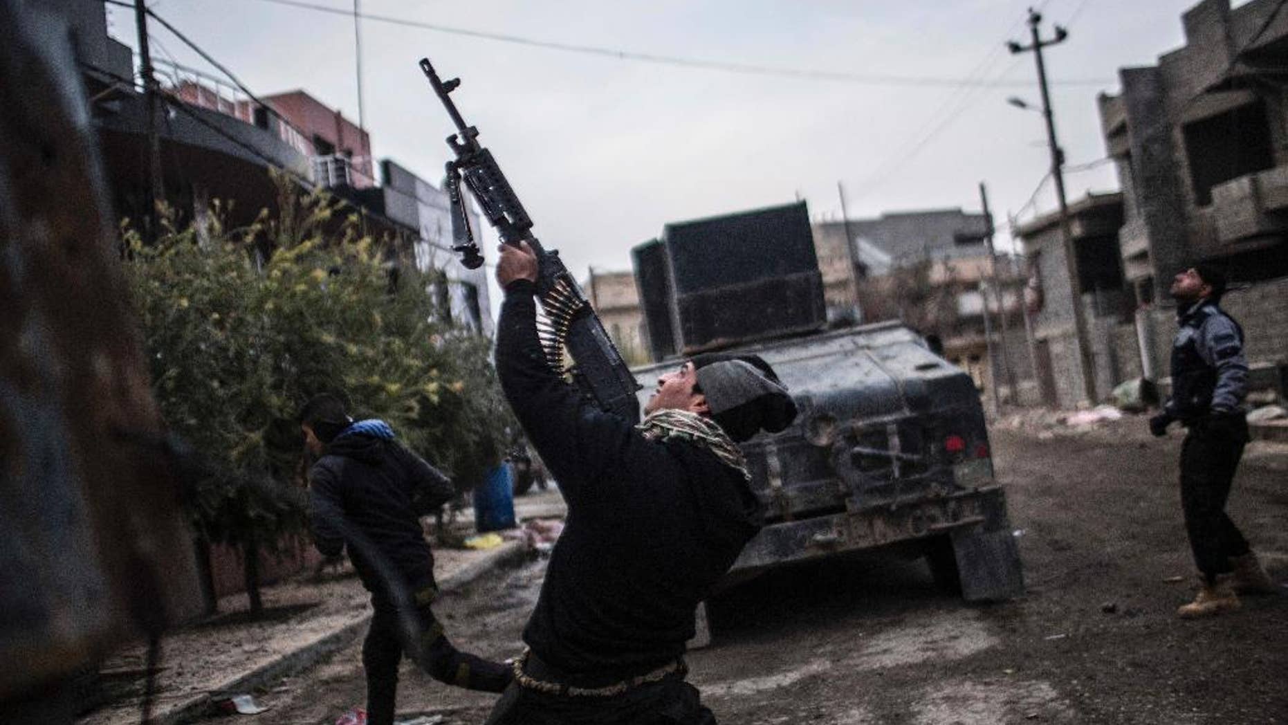 In this Sunday, Dec. 18, 2016 file photo, a member of the Iraqi Special Forces shoots his machine gun against an Islamic State militant drone n the al-Barid district in Mosul, Iraq. Iraqi forces sitting for weeks on the edges of Mosul have been bolstered by reinforcements and are now ready, along with the elite special forces, to launch a stepped up, three-pronged assault against Islamic State group militants in the city’s eastern sector, ending a two-week lull in the fighting, a top Iraqi general told The Associated Press on Wednesday, Dec. 28, 2016. (AP Photo/Manu Brabo, File)