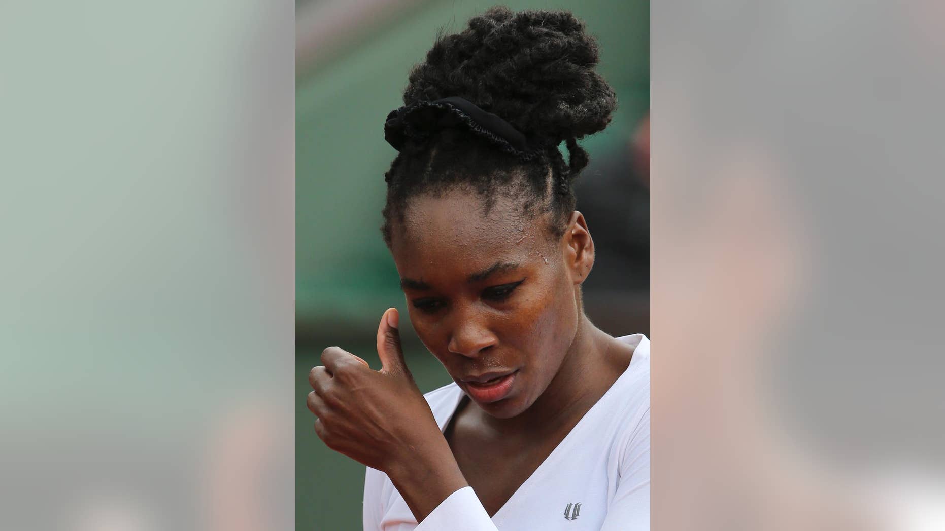 Venus Williams of the U.S. wipes away some beads of sweat during the second round match of the French Open tennis tournament against Slovakia's Anna Schmiedlova at the Roland Garros stadium, in Paris, France, Wednesday, May 28, 2014. (AP Photo/David Vincent)