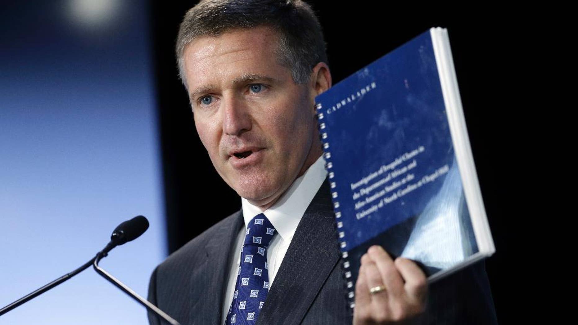 FILE - In this Oct. 22, 2014, file photo, Kenneth Wainstein, lead investigator into academic irregularities at the University of North Carolina at Chapel Hill, holds a copy of his findings following a special joint meeting of the University of North Carolina Board of Governors and the UNC-Chapel Hill Board of Trustees in Chapel Hill, N.C. The findings revealed academic fraud involving more than 3,100 students. North Carolina is scheduled to appear before an NCAA infractions committee panel Oct. 28 in the case tied to its long-running academic fraud scandal. (AP Photo/Gerry Broome, File0