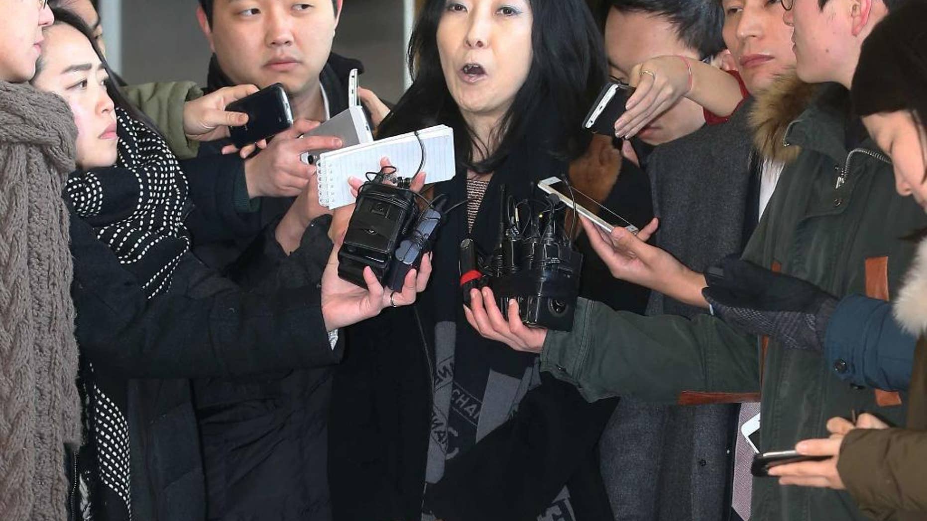 In this Wednesday, Jan. 7, 2015, photo, California-resident Shin Eun-mi, center, talks to the reporters at Seoul District Prosecutors' Office in Seoul, South Korea. South Korean officials said Friday, Jan. 9 they were considering whether to deport the Korean-American woman accused of praising rival North Korea during a recent lecture. (AP Photo/Yonhap, Park Ji-ho) KOREA OUT