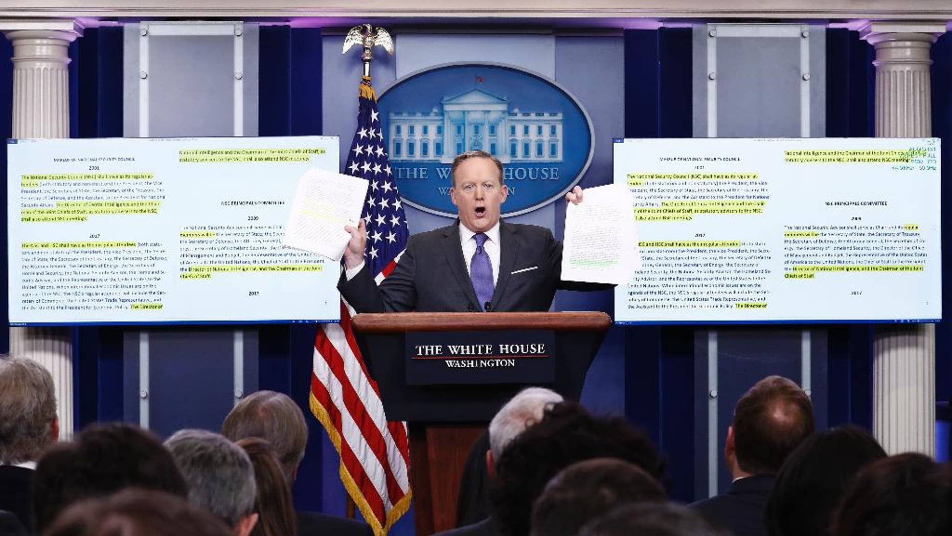 White House press secretary Sean Spicer holds up paperwork about the National Security Council as he speaks during the daily news briefing at the White House in Washington, Monday, Jan. 30, 2017. (AP Photo/Carolyn Kaster)