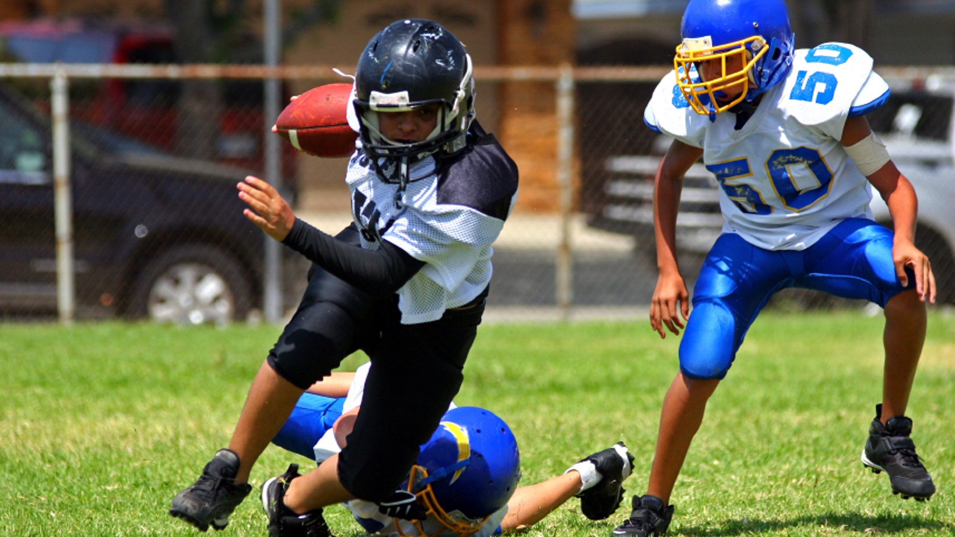 Young american football player running back breaking away from an attempted tackle.