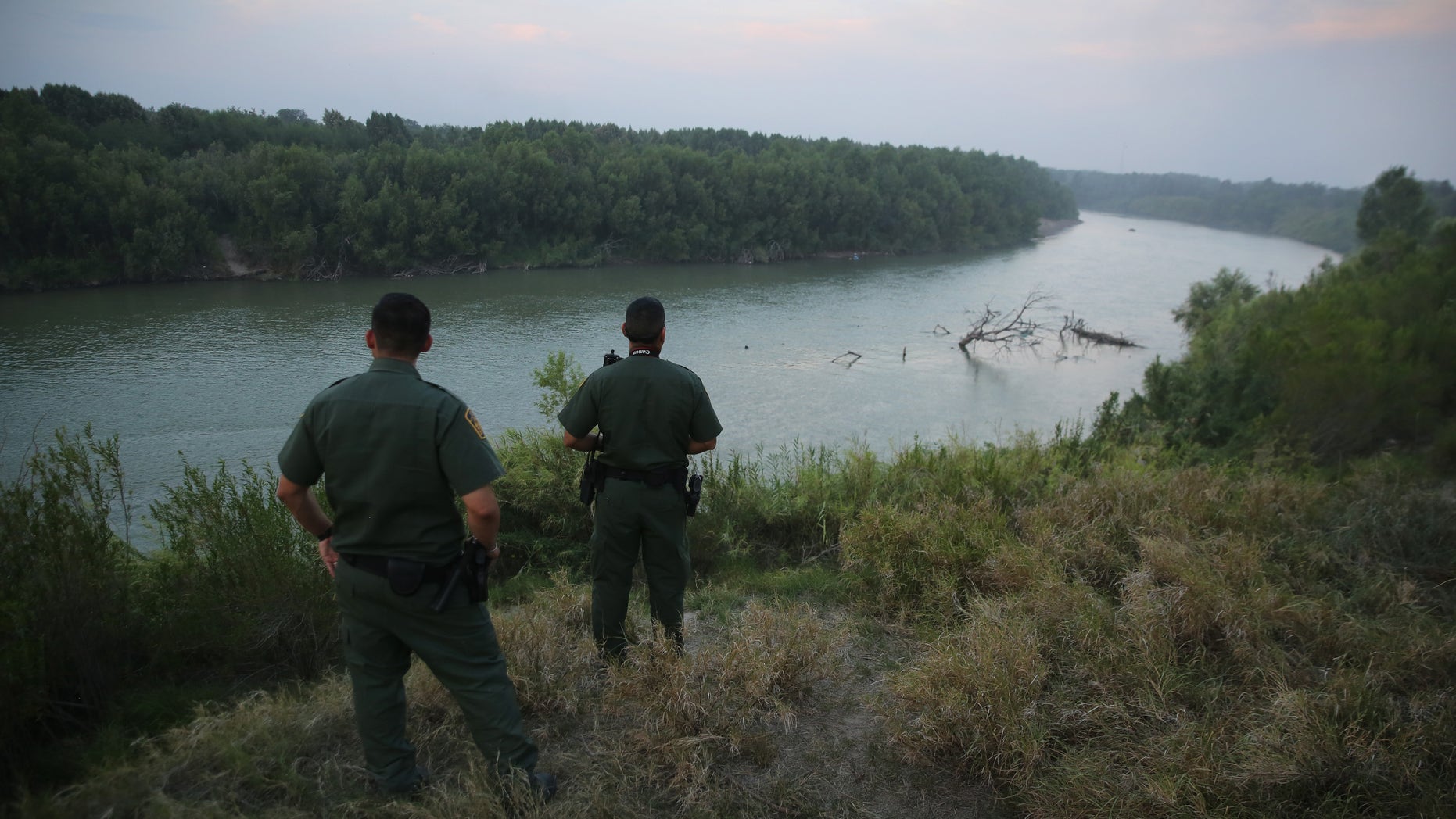 MISSION, TX - JULY 24: U.S. Border Patrol agents look for immigrants crossing the Rio Grande from Mexico (L), to the United States at dusk on July 24, 2014 near Mission, Texas. Tens of thousands of undocumented immigrants, many of them families or unaccompanied minors, have crossed illegally into the United States this year and presented themselves to federal agents, causing a humanitarian crisis on the U.S.-Mexico border. Texas' Rio Grande Valley has become the epicenter of the latest immigrant crisis, as more immigrants, especially Central Americans, cross illegally from Mexico into that sector than any other stretch of the America's 1,933 mile border with Mexico. (Photo by John Moore/Getty Images)