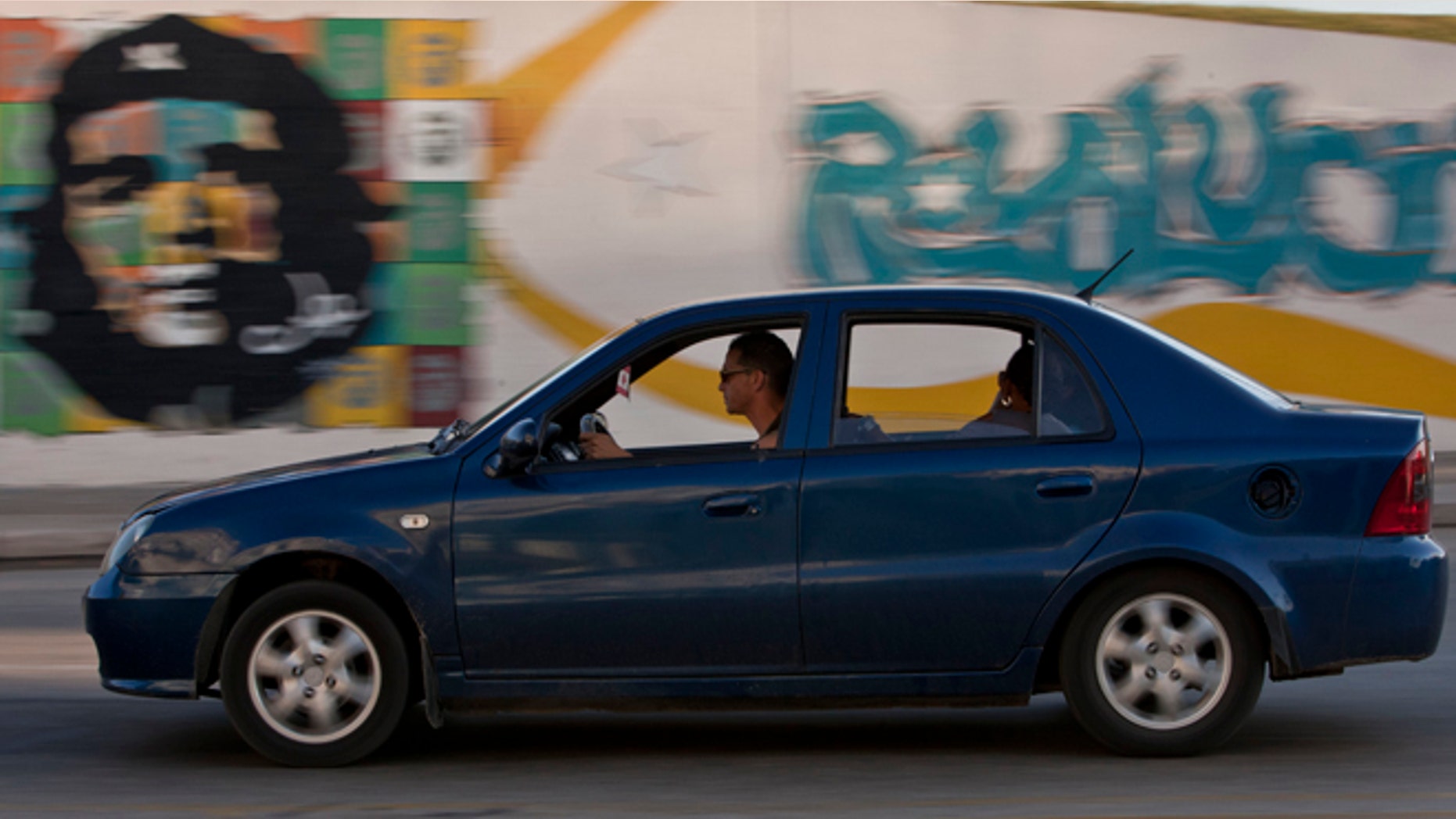 In this July 7, 2014, photo, a Chinese made vehicle passes in front of a mural of revolutionary hero Ernesto "Che" Guevara in Havana, Cuba. A new law took effect in January letting Cubans buy cars from the government freely for the first time in decades. The euphoria that greeted the law turned to anger when the exhorbitant prices were posted. (AP Photo/Franklin Reyes)