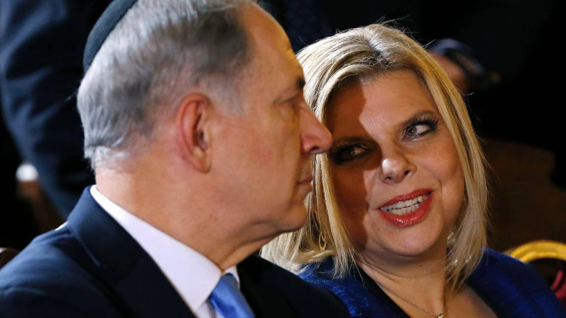 FILE - In this Israeli Dec. 1, 2013. file photo, Prime Minister Benjamin Netanyahu listens to his wife Sara during a meeting with the Roman Jewish Community at the Great Synagogue in Rome. Israeli media say police are questioning the wife of Prime Minister Benjamin Netanyahu over her alleged improper use of public funds. According to multiple media reports, police are looking into claims that Sara Netanyahu used state funds to care for her late father, to pay for private chefs at private family events, and to furnish the Netanyahus' private home near the Mediterranean beach. (AP Photo/Riccardo De Luca, File)