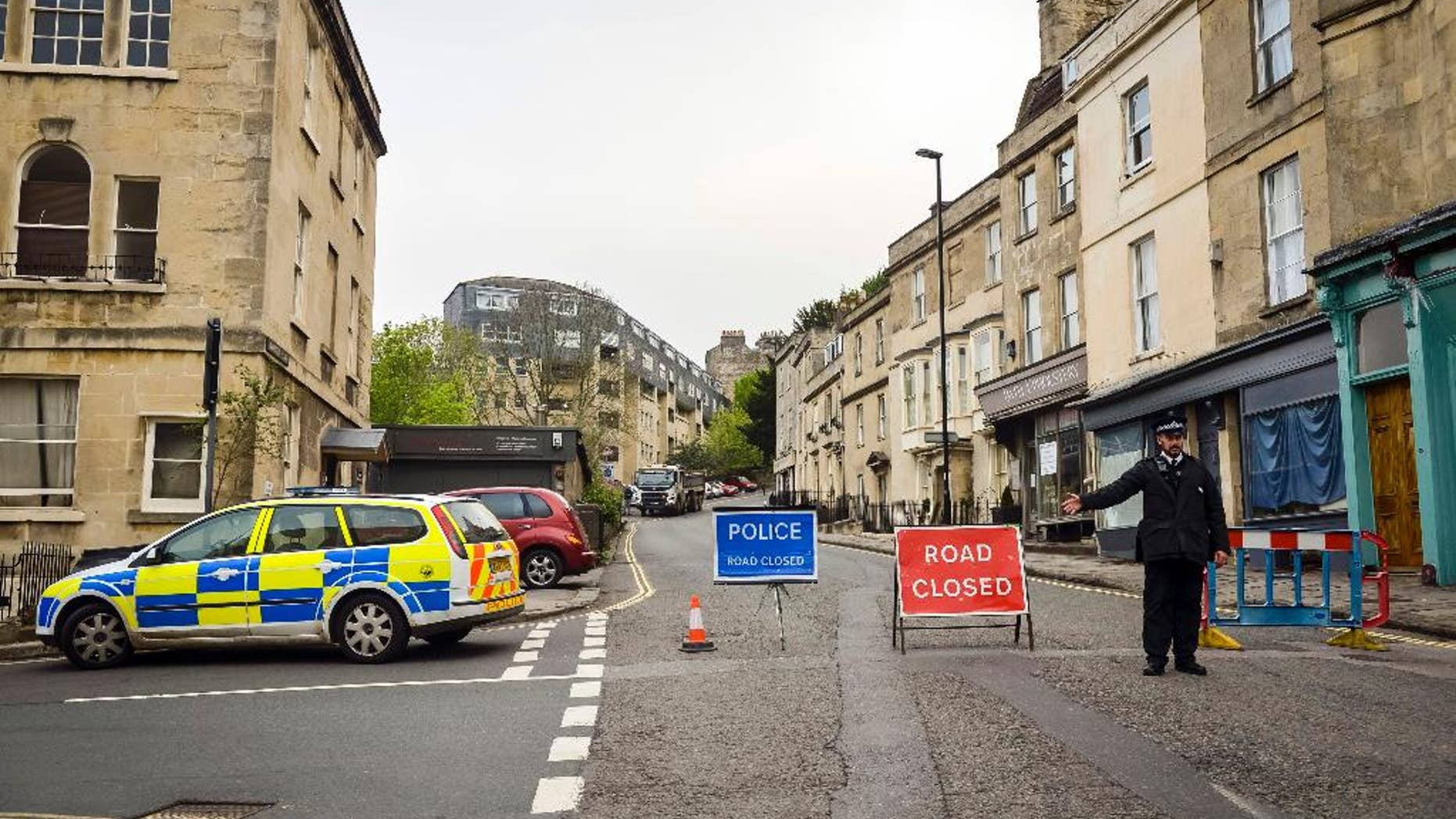 Police divert away traffic from an exclusion zone set up after contractors unearthed a Second World War shell in Bath, England, Friday, May 13, 2016. Hundreds of people have been told to leave homes and businesses in the English city of Bath after a 500-pound (225-kilogram) unexploded World War II shell was found under a school playground. Police evacuated residents for 300 meters (yards) around the device, found during construction work at the disused Royal High School. Some spent the night at a local racecourse. (Ben Birchall/PA via AP) UNITED KINGDOM OUT - NO SALES - NO ARCHIVES
