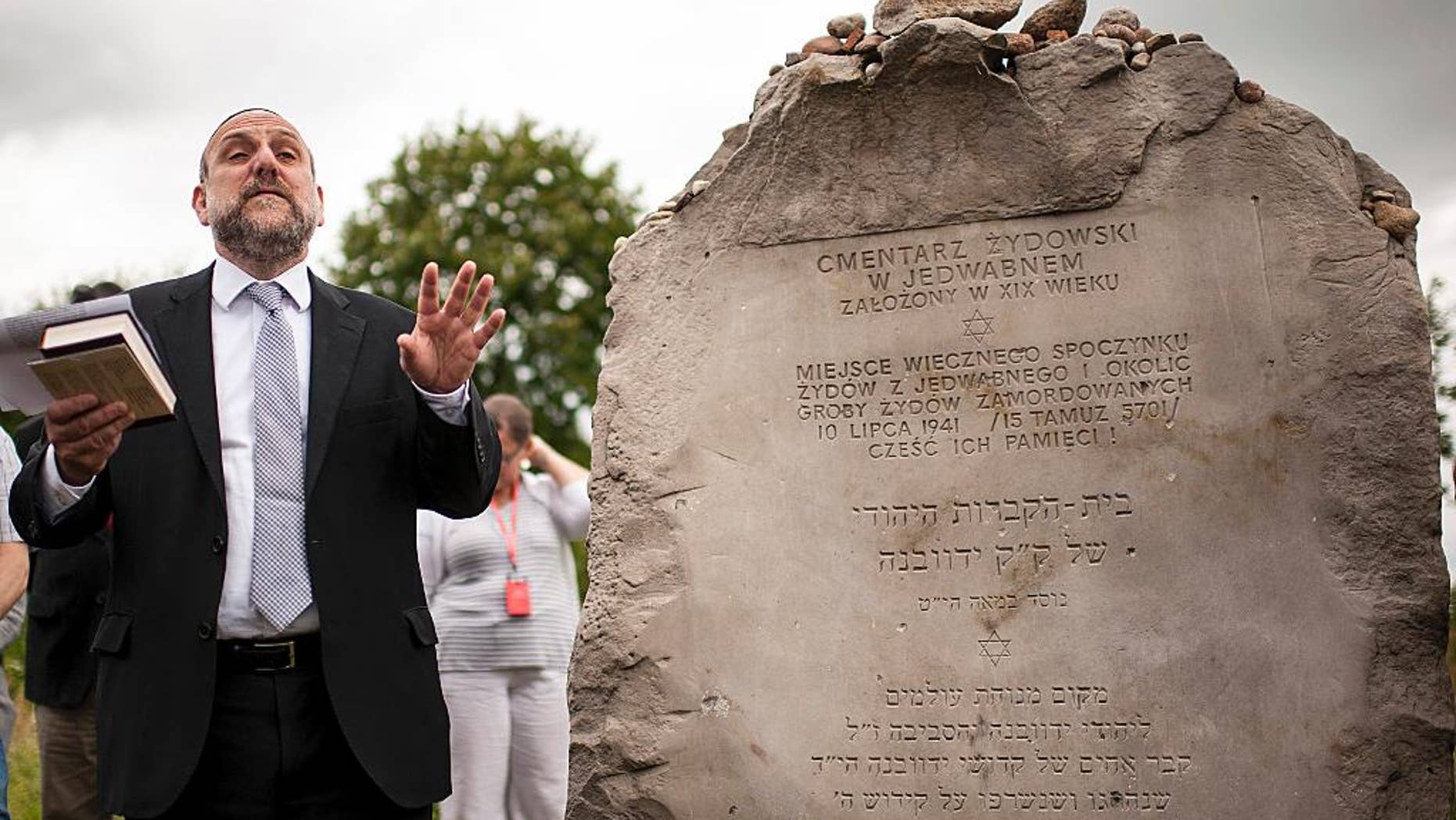 FILE - In this Sunday July 10, 2016 file photo, Poland's chief rabbi Michael Schudrich prays during commemorations marking the 75th anniversary of a massacre of Jews in Jedwabne, Poland. The education minister in Poland’s right-wing government has sparked criticism for appearing to deny Polish responsibility for two massacres of Jews in the 1940s. Anna Zalewska’s comments on Wednesday, July 13 raised questions about the commitment by the populist ruling party, Law and Justice, both to historical truth and to opposing anti-Semitism. (AP Photo/Michal Kosc, file)