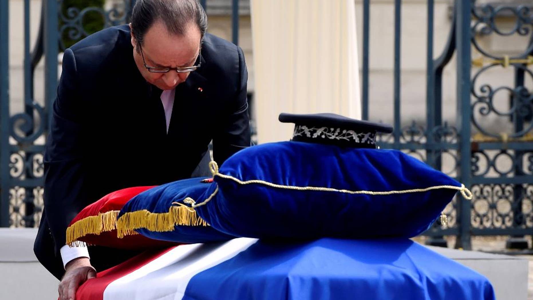 French President Francois Hollande pays his respects at the coffin of one the two police officials killed.