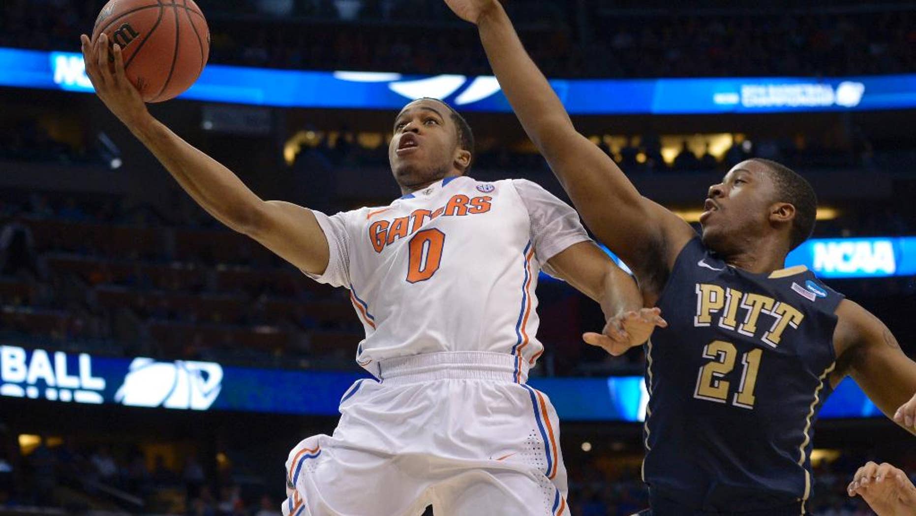 Florida guard Kasey Hill (0) drives to the basket as Pittsburgh forward Lamar Patterson (21) defends during the first half in a third-round game in the NCAA college basketball tournament Saturday, March 22, 2014, in Orlando, Fla. (AP Photo/Phelan M. Ebenhack)