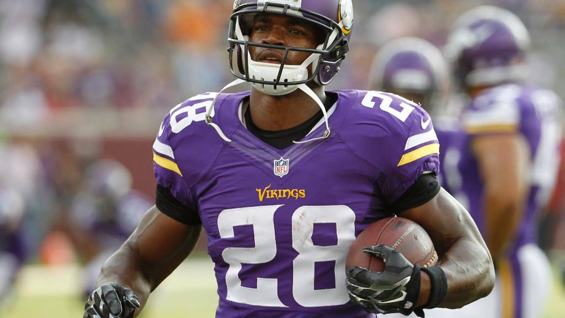 In this Aug. 16, 2014, photo, Minnesota Vikings running back Adrian Peterson (28) warms up before a NFL preseason football game against the Arizona Cardinals in Minneapolis.Millions of people using the top three fantasy football platforms have generated three different answers to the question of that top draft pick. Yahoo says LeSean McCoy of Philadelphia. ESPN says Adrian Peterson. CBS Sports says it’s Jamaal Charles of Kansas City. (AP Photo/Ann Heisenfelt)