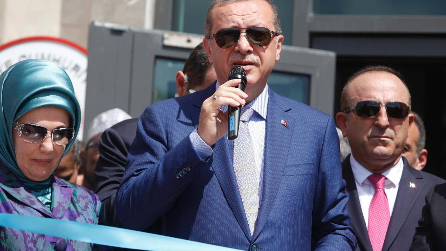 From left to right; Turkey's First Lady Emine Erdogan, Turkey's President Recep Tayyip Erdogan, and Turkey's Foreign Minister Mevlut Cavusoglu attend a ceremony to open a new Turkish embassy in Mogadishu, Somalia Friday, June 3, 2016. Erdogan opened the new Turkish embassy in Somalia's capital on Friday amid heavy security less than two days after militants attacked a hotel in the city, killing 15 people. (AP Photo/Farah Abdi Warsameh)