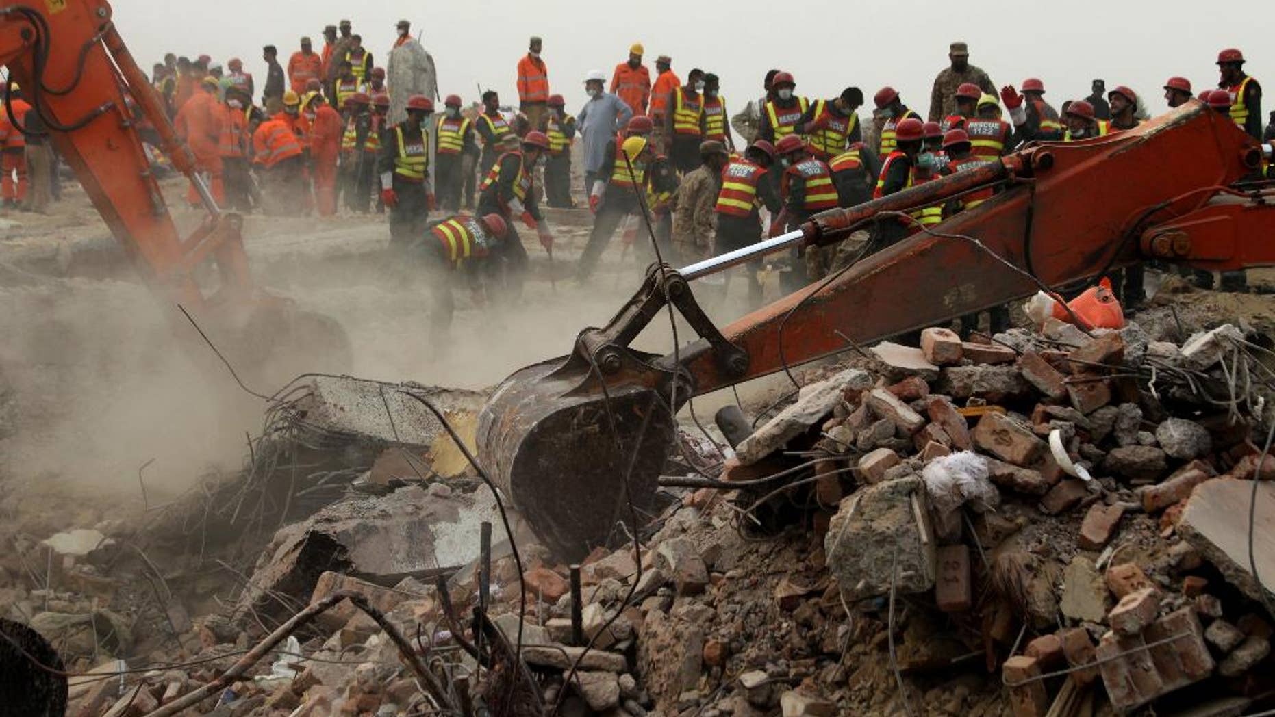 Excavators dig rubble of a collapsed building looking for survivors in Lahore, Pakistan, Friday, Nov. 6, 2015. A spokesman for a Pakistani rescue agency says hopes are starting to fade for finding more survivors in the rubble of a four-story factory which collapsed this week killings dozens of people left many injured. (AP Photo/K.M. Chaudary)