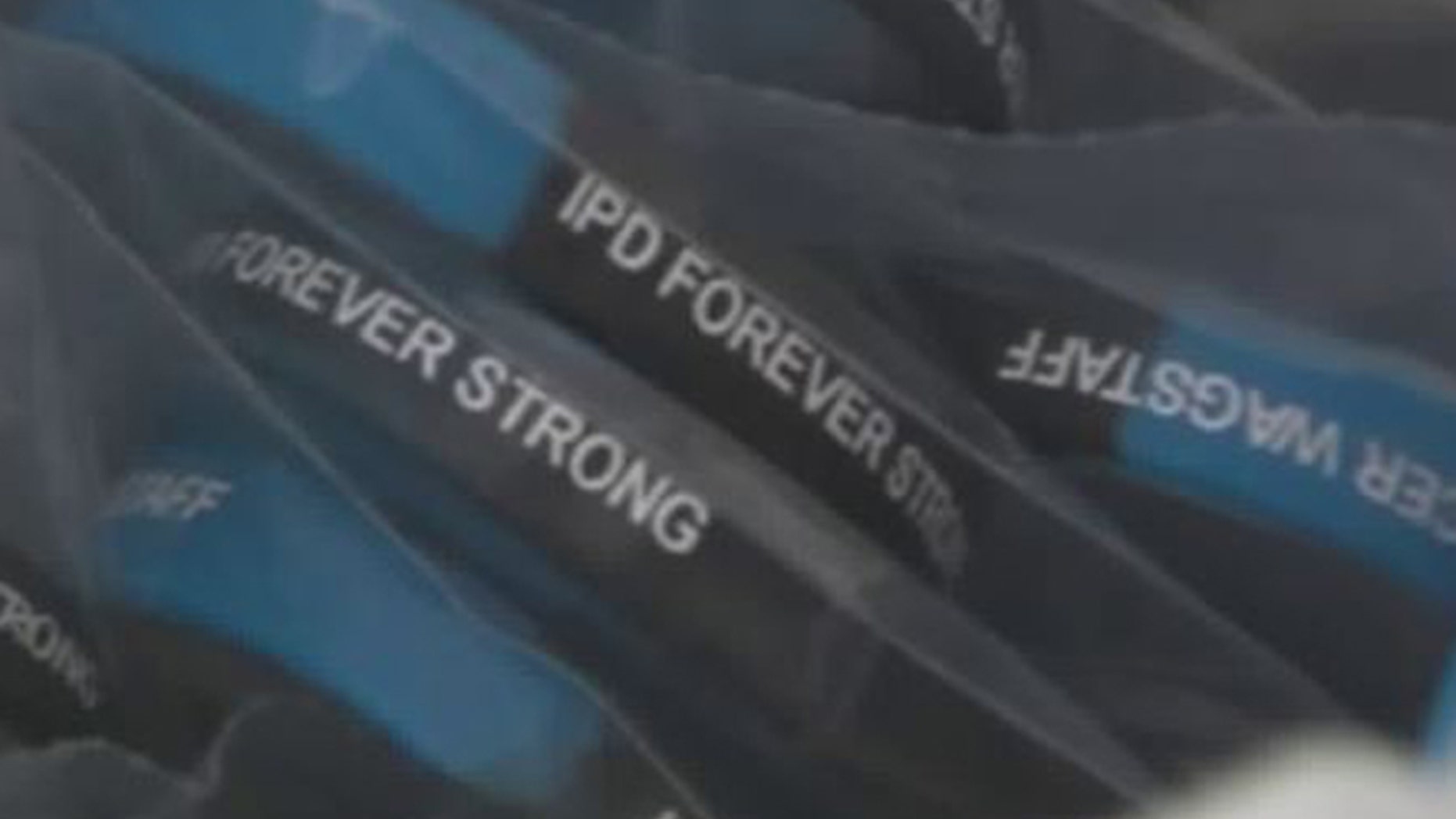 The wristbands read "IPD Forever Strong," with the officer's name.