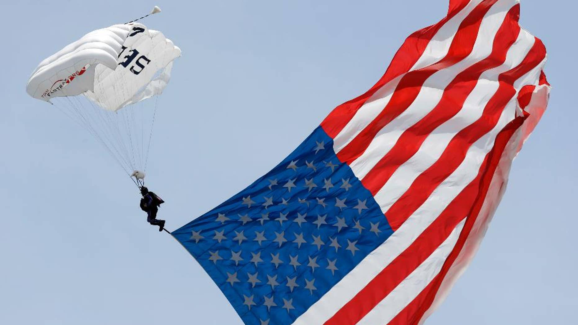 A parachutist descends into the Charlotte Motor Speedway prior to a NASCAR Xfinity Series auto race in Concord, N.C., Saturday, May 28, 2016. (AP Photo/Gerry Broome)