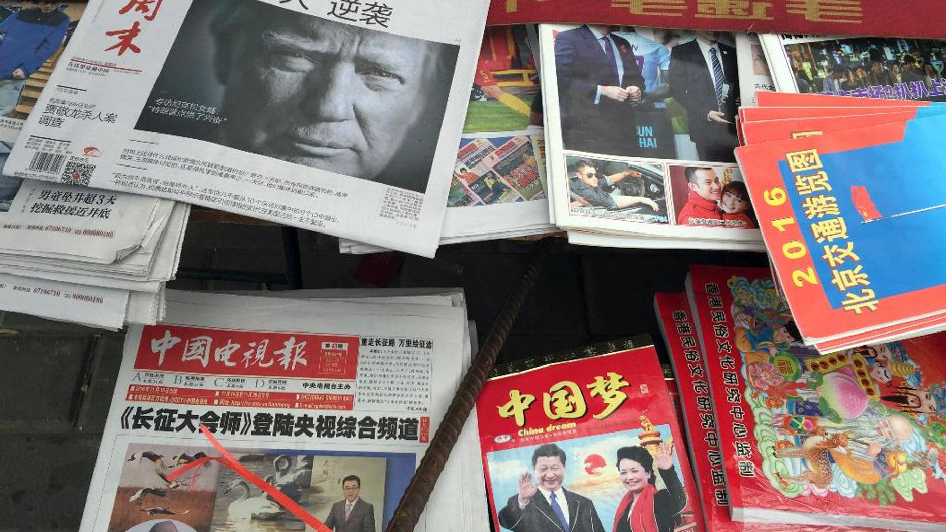 A front page of a Chinese newspaper with a photo of U.S. President-elect Donald Trump and the headline "Outsider counter attack" is displayed at a newsstand in Beijing, China, Thursday, Nov. 10, 2016. Trump is a mixed blessing for Chinese leaders. His threats to tear up trade deals and hike tariffs on Chinese goods could chill thriving commercial ties when Beijing is struggling to shore up economic growth. At the same time, Trump’s suggestion he might reduce Washington’s global strategic presence to focus on domestic issues would be a gift to Chinese leaders. They could expand their political and military profile in East Asia with less risk of conflict. (AP Photo/Ng Han Guan)