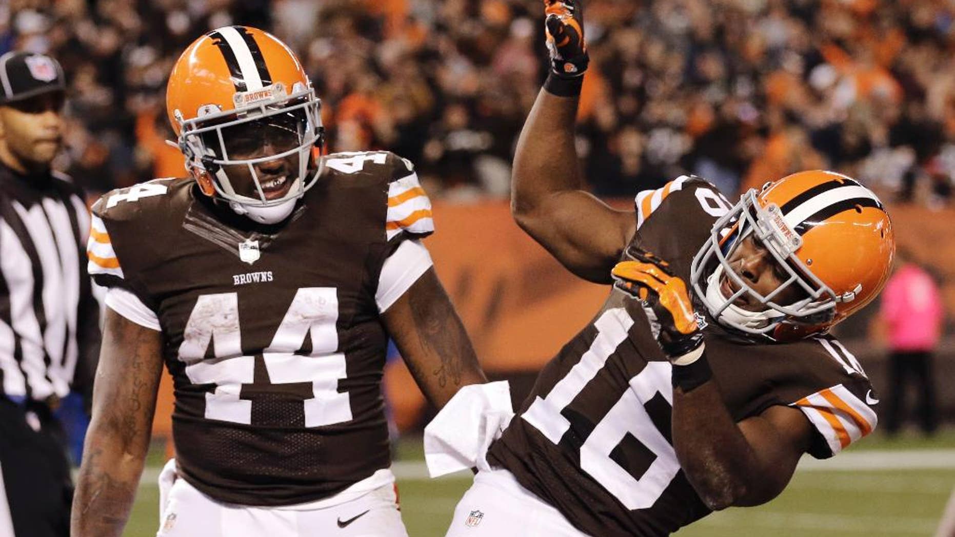 Cleveland Browns wide receiver Andrew Hawkins (16) celebrates running back Ben Tate's (44) 5-yard touchdown run in the fourth quarter of an NFL football game against the Oakland Raiders, Sunday, Oct. 26, 2014, in Cleveland. (AP Photo/Tony Dejak)