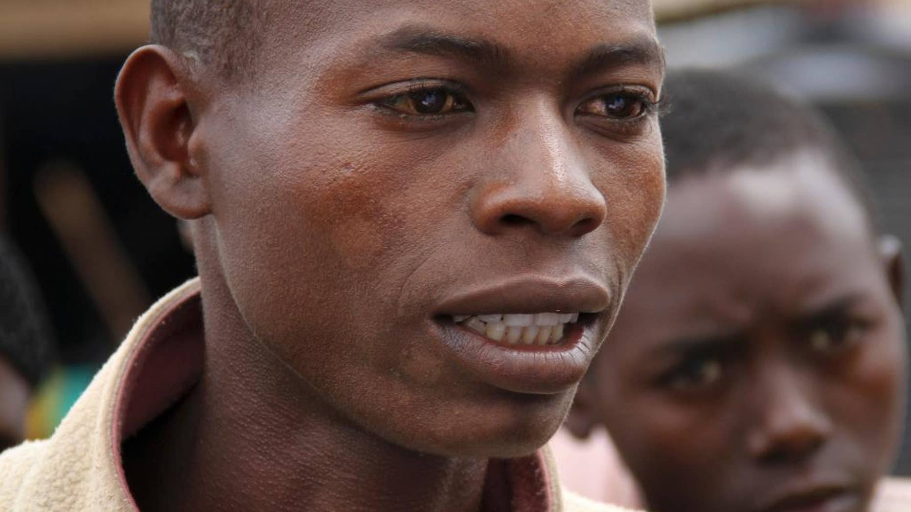 In this photo taken Tuesday, April 21, 2015, Burundian refugee Jean de Dieu Niyibizi, 27, one of many who have crossed to Rwanda, speaks about his journey and why he fled, at the Gashora refugee camp, in the Bugesera district of Rwanda. More than 10,000 people from the East African nation of Burundi have crossed into neighboring Rwanda amid threats of violence ahead of elections, with many arriving saying they have been intimidated by thugs who support President Pierre Nkurunziza who may seek a third term. (AP Photo/Edmund Kagire)