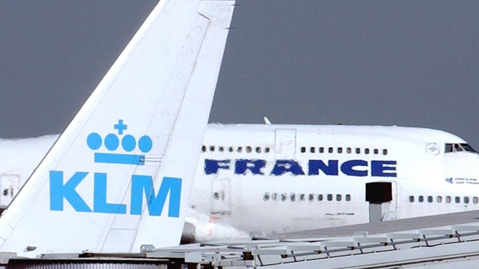FILE -- In this Sept. 30, 2003 file photo, an Air France jumbo jet rolls behind the tail of a KLM Royal Dutch airliner at Charles de Gaulle airport in Roissy, north of Paris. KLM said Wednesday, Sept. 14, 2016 that it will temporarily suspend flights to and from Cairo in January, citing “economic reasons.” The Royal Dutch Airlines’ statement said the devaluation of the Egyptian pound and restrictions imposed by the country’s central bank on the transfer of foreign currency out of Egypt are behind the decision. (AP Photo/Remy de la Mauviniere, File)