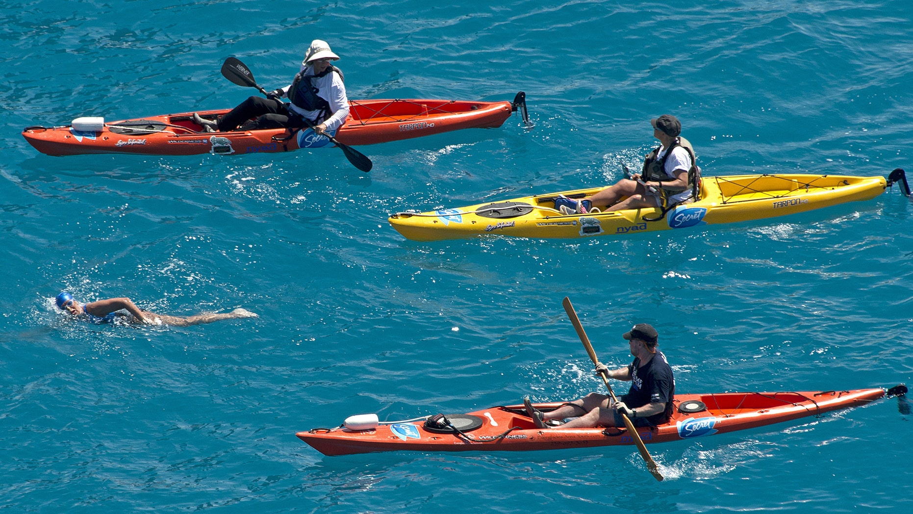 In this photo provided by the Florida Keys News Bureau, Diana Nyad, positioned about two miles off Key West, Fla., Monday, Sept. 2, 2013, is escorted by kayakers as she swims towards the completion of her approximately 110-mile trek from Cuba to the Florida Keys. Nyad, 64, is poised to be the first swimmer to cross the Florida Straits without the security of a shark cage. (AP Photo/Florida Keys News Bureau, Andy Newman)