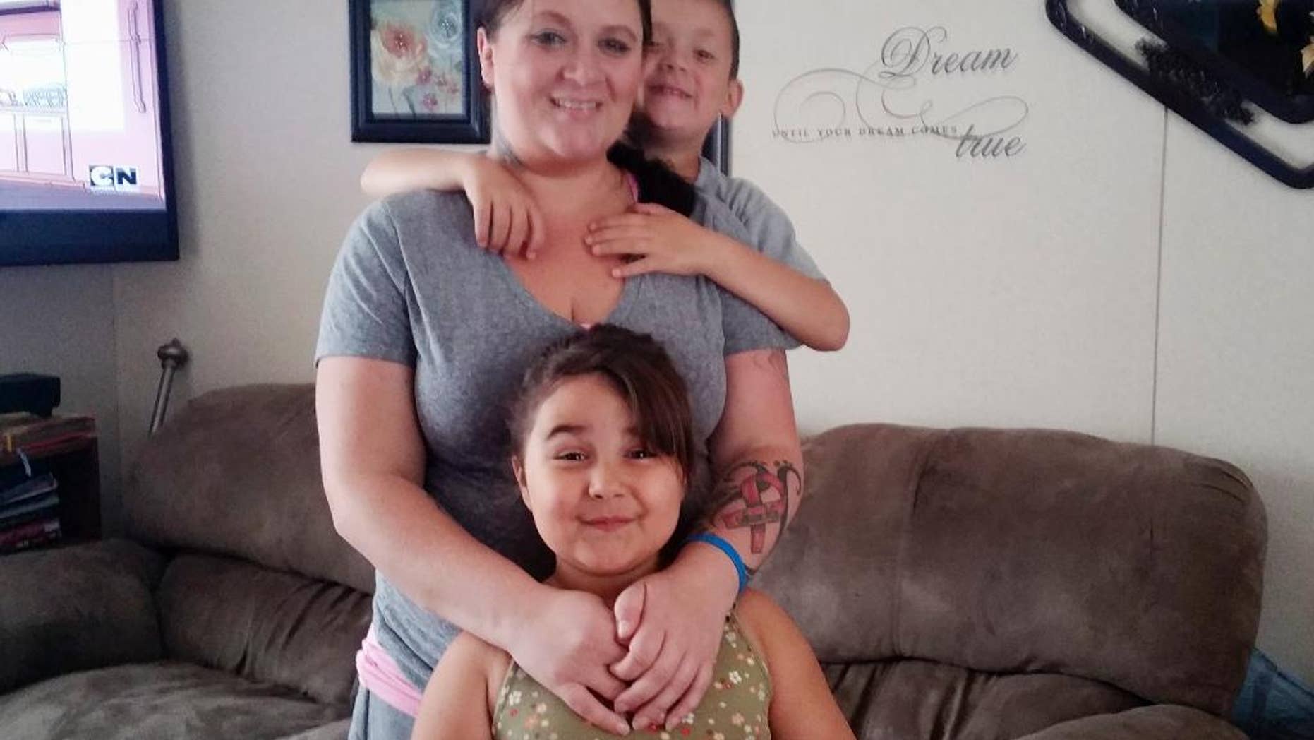 This June 21, 2015 family photo provided by Elizabeth Garcia shows Garcia posing with her children Cristian, rear, and Nayeli, at their home in Watford City, N.D. The oil industry slump is leading to layoffs in North Dakota’s oil patch, but Garcia, who was laid of before Christmas, has found some surprising support. Garcia couldn’t buy presents for her two kids, so she put her plight on Facebook and tried to sell an old camper she owned. The response was overwhelming. (AP Photo/Elizabeth Garcia via AP)