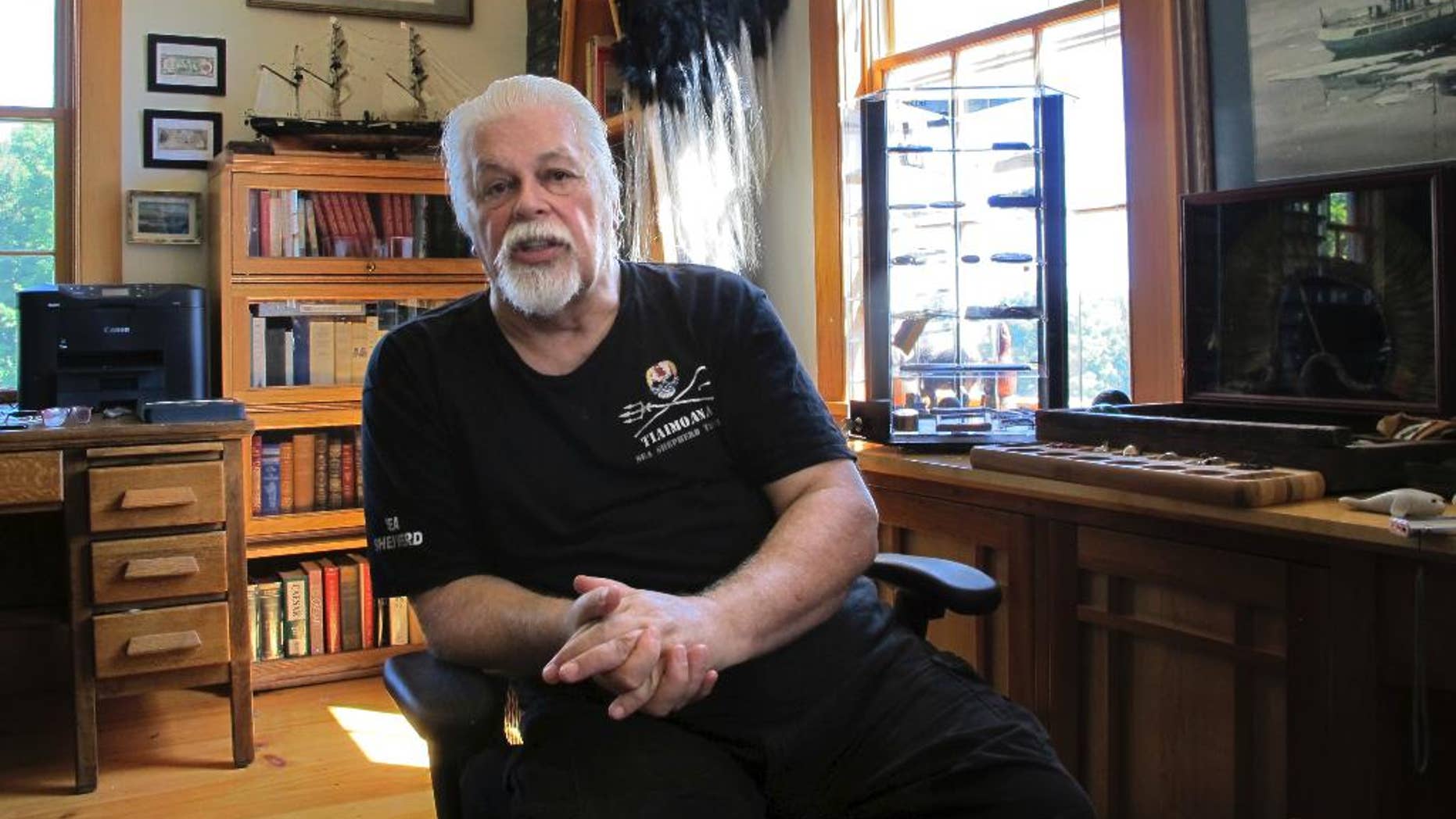 In this Aug. 23, 2016 photo, Paul Watson, founder of the Sea Shepherd Conservation Society, made famous by the television show "Whale Wars" discusses a recent legal battle over anti-whaling activities, at his home office in Woodstock, Vt. Japan's Institute of Cetacean Research and a whale ship operator announced this week they'd reached an agreement with Sea Shepherd Conservation Society over those anti-whaling activities. Watson said the settlement only prevents the group's U.S. organization from interfering with Japanese whalers in the Southern Ocean. (AP Photo/Lisa Rathke)