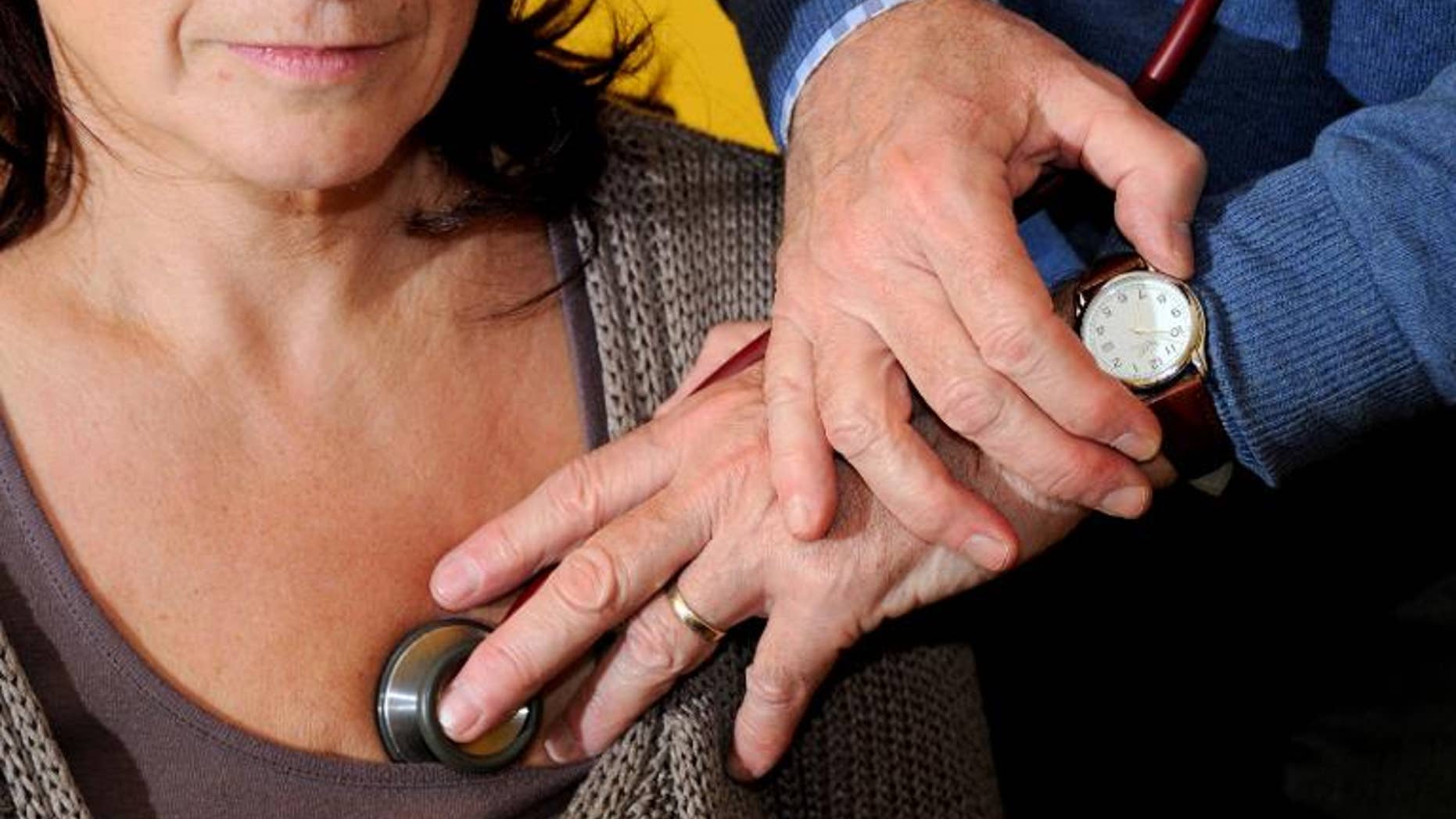 A doctor examines a patient in Godewaersvelde, northern France on September 25, 2012