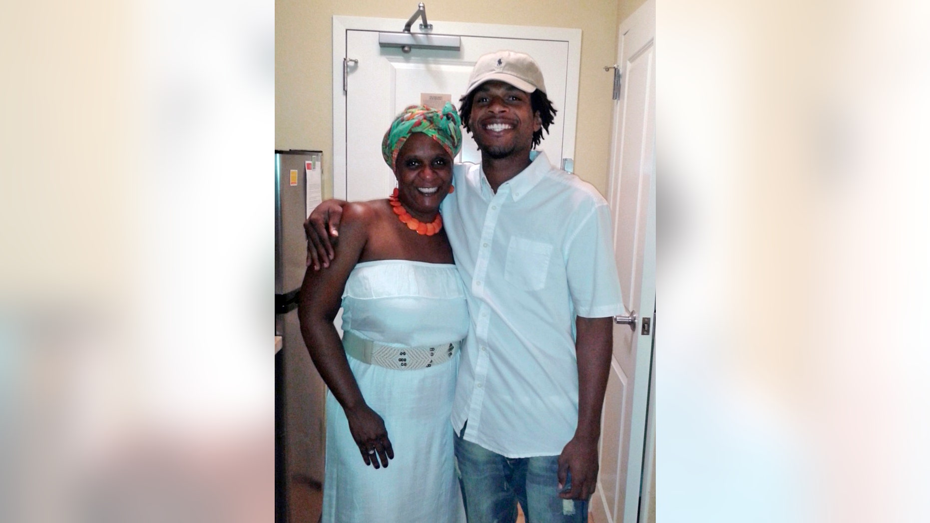 FILE - This undated file photo provided by the family of John Crawford III shows Crawford, right, with his mother Tressa Sherrod. Two years after a white policeman fatally shot John Crawford III on Aug. 5, 2014, in a Wal-Mart store in the Dayton suburb of Beavercreek, Ohio, as Crawford carried an air rifle picked up from a store shelf, the U.S. Justice Department has yet to conclude its investigation and won't say why, despite the family's push for an update. (Courtesy Family of John Crawford III via AP, File)