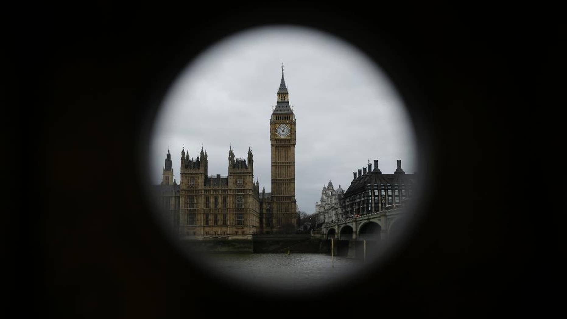 The Houses of Parliament and Elizabeth Tower containing the bell know as "Big Ben" are framed by a hole in a stand that used to house a telescope for tourists to use in London, Monday, March 20, 2017. Britain's government will begin the process of leaving the European Union on March 29, starting the clock on the two years in which to complete the most important negotiation for a generation. (AP Photo/Matt Dunham)