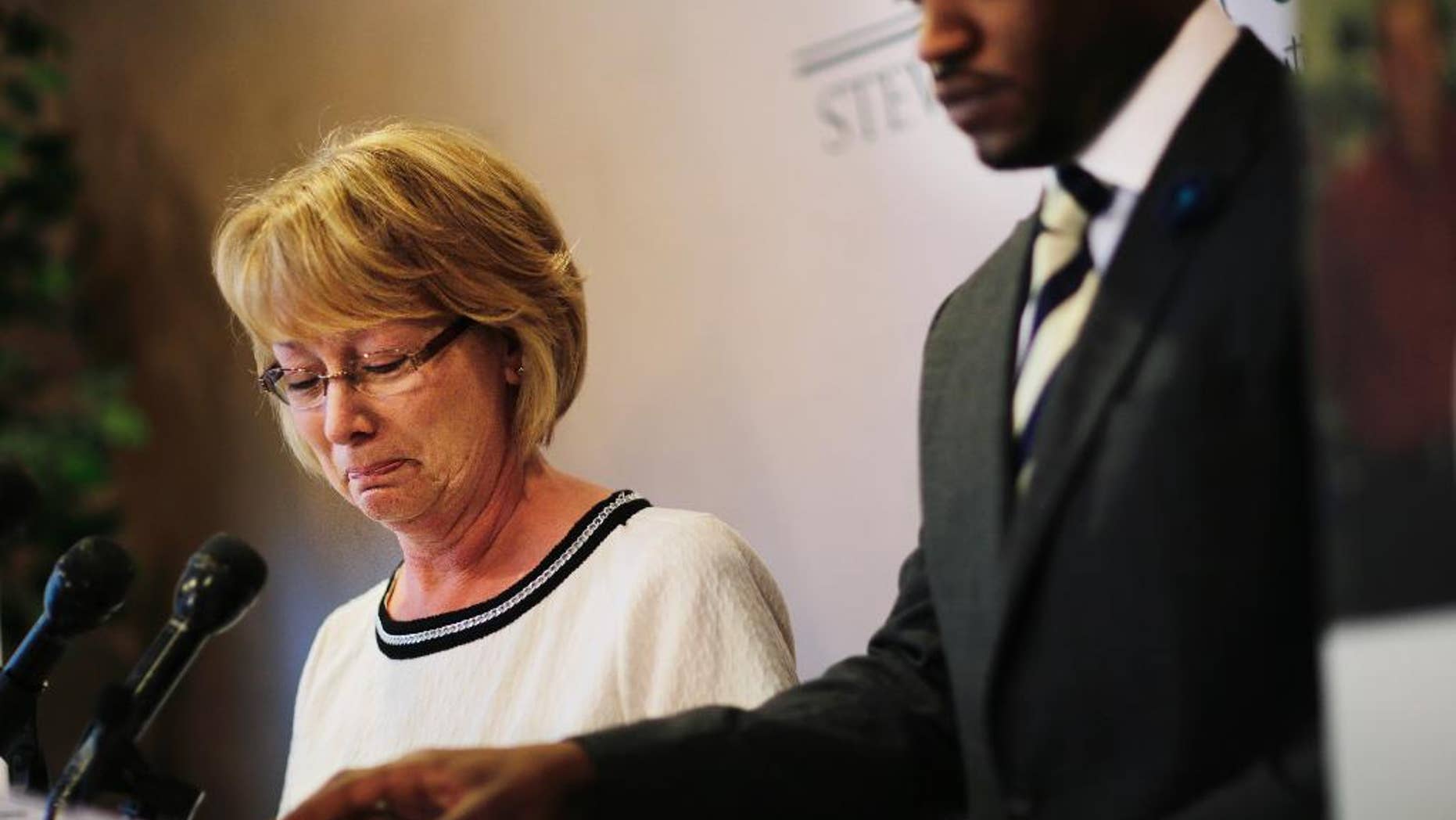 Mary Ann Sherman, left, weeps during a news conference with her attorney Chris Stewart, right, in response to a video showing her son's struggle with police officers Friday, May 20, 2016, in Atlanta. Two deputies yell "Stop fighting!" and "He's got my Taser!" as they repeatedly stun Chase Sherman, handcuffed in the back of a vehicle, commanding him to relax even as he insists "I'm dead," shortly before he stops breathing, body-camera video from the incident shows. The video shows the Nov. 20 incident in the back of an SUV in Coweta County, outside Atlanta. Sherman, 32, of Destin, Florida, was pronounced dead at a hospital later that day.(AP Photo/David Goldman)
