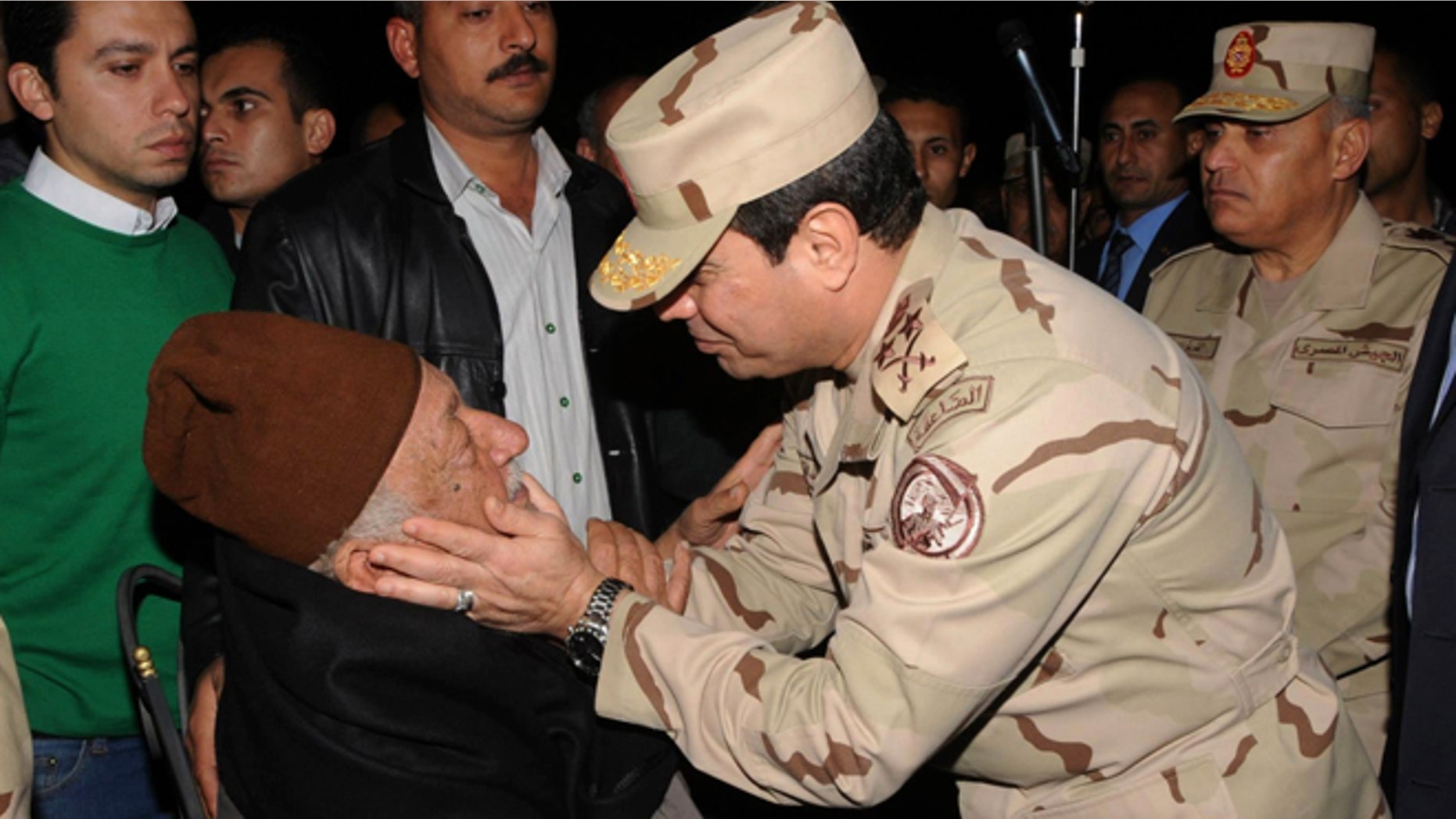 In this undated photo released by the Egyptian Defense Ministry, Defense Minister Gen. Abdel-Fattah el-Sissi consoles a man at a funeral for several military personnel who were killed when a helicopter crashed in the Sinai Peninsula, at an undisclosed location in Egypt.