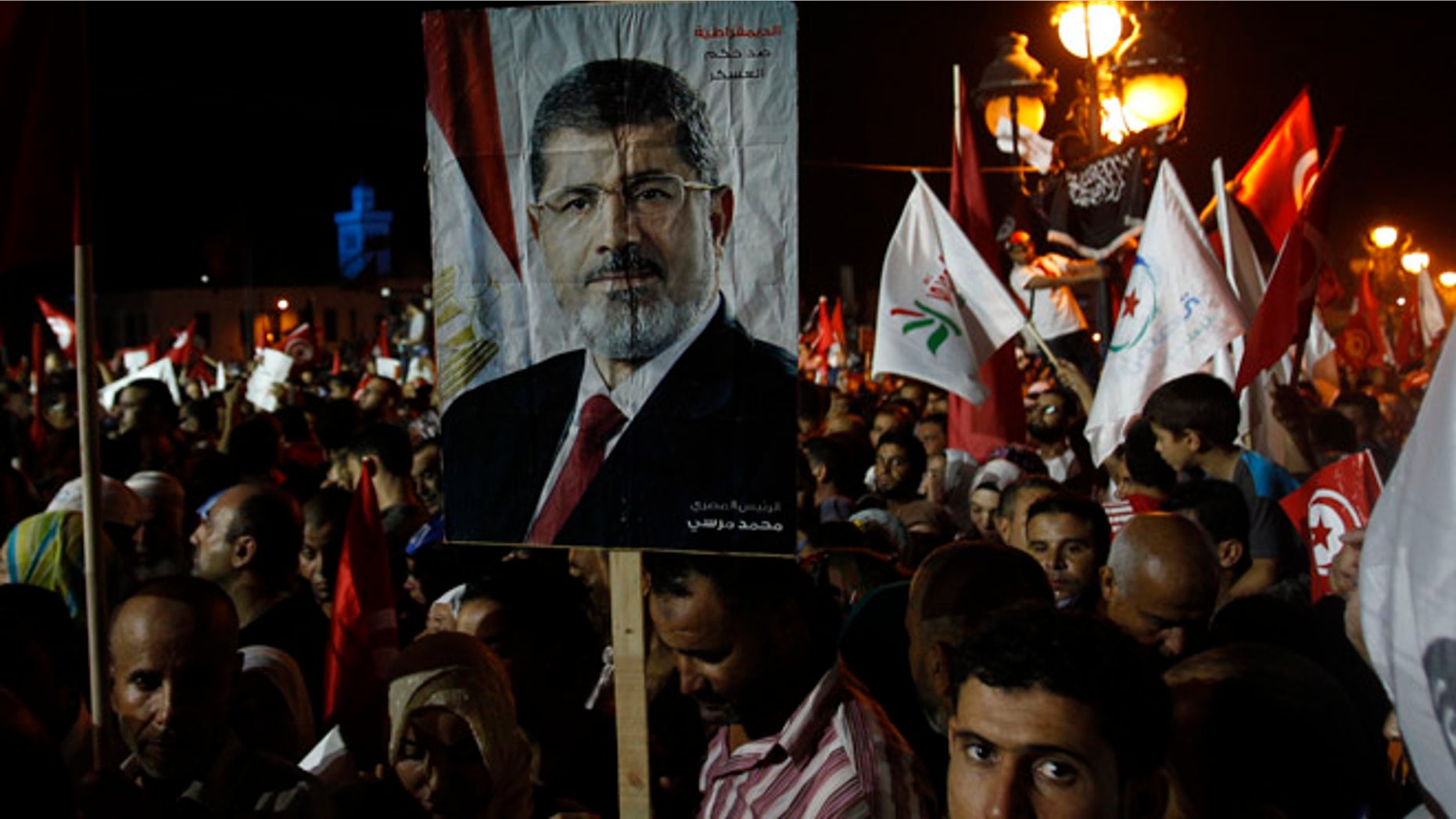 Aug 3, 2013: Supporters of the Islamist Ennahda movement hold a portrait of ousted Egyptian President Mohamed Morsi during a demonstration at Kasbah Square in Tunis.