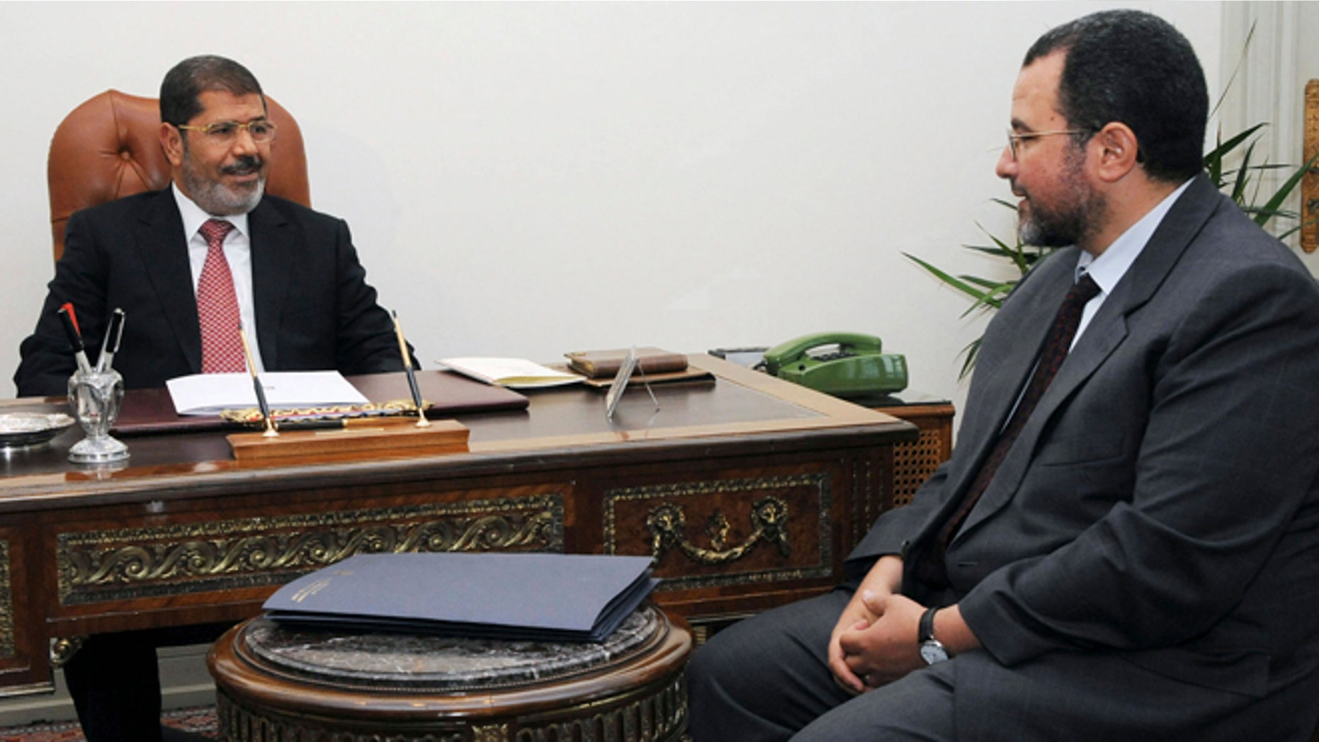 FILE - In this Sunday, July 22, 2012 file photo released by the Egyptian Presidency, Egyptian President, Mohammed Morsi, left, meets with the minister of Water Resources and Irrigation, Hesham Kandil, at the Presidential Palace in Cairo.