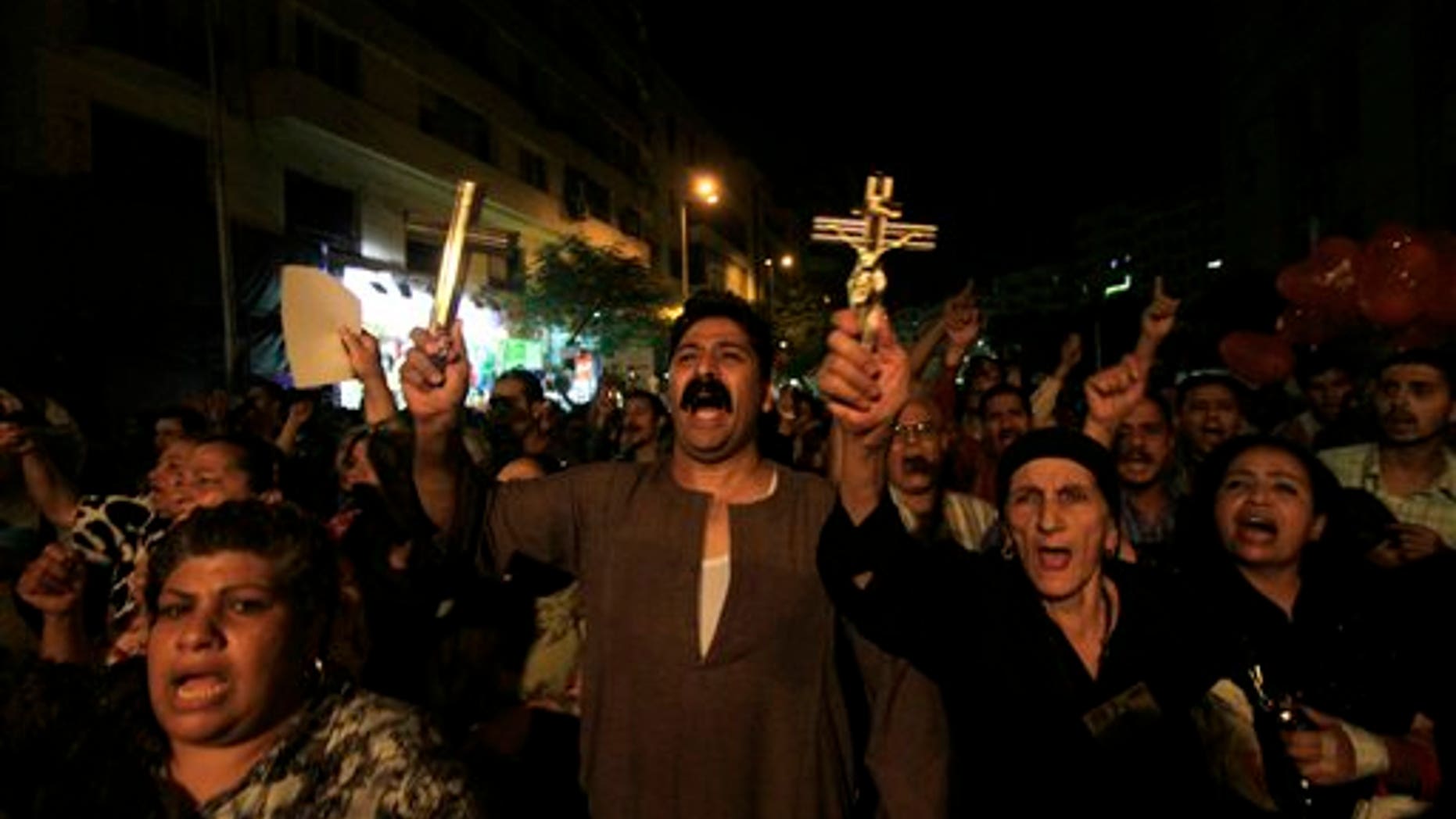 Oct. 4: In this file photo, Egyptian Copts hold Christian crosses and chant slogans as they demonstrate against the sectarian violence, in downtown Cairo, Egypt. In the past few weeks, riots have broken out at two churches in southern Egypt, prompted by Muslim crowds angered by rumors that Christians were building new churches.