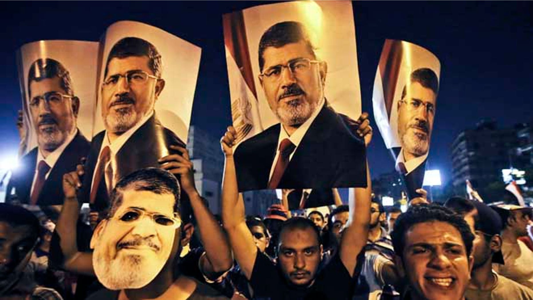July 10, 2013: Supporters of ousted Egypt's President Mohammed Morsi, hold posters of him as they protest during the Islamic month of Ramadan, in Nasr City, Cairo, Egypt.
