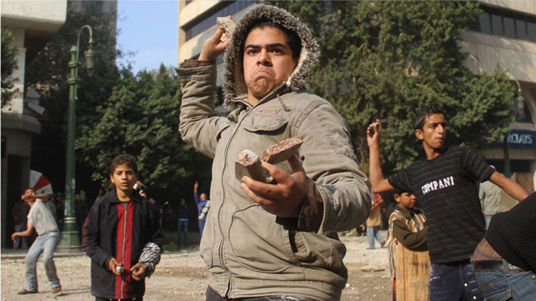 Dec. 16, 2011: Egyptian protesters throw rocks at military police during clashes near Cairo's downtown Tahrir Square, Egypt.
