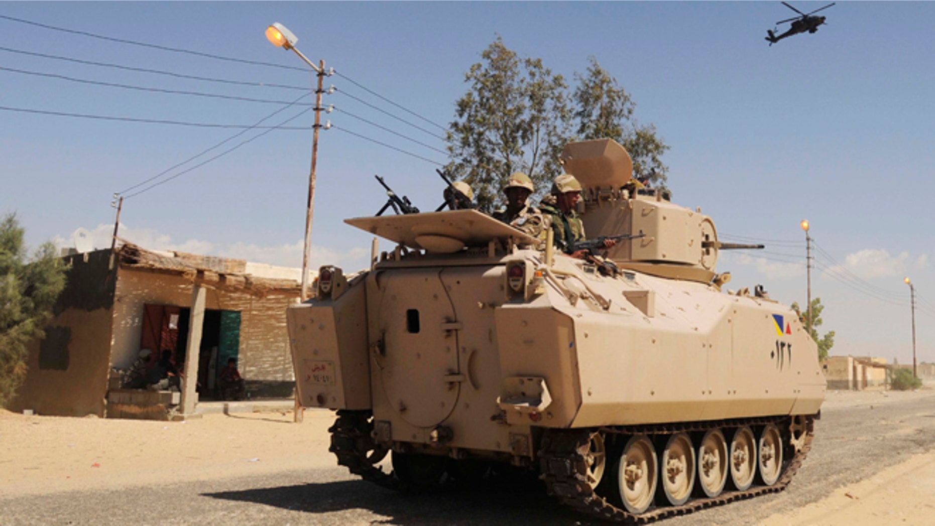 May 21, 2013: In this file photo, Egyptian Army soldiers patrol in an armored vehicle backed by a helicopter gunship during a sweep through villages in Sheikh Zuweyid, northern Sinai, Egypt.