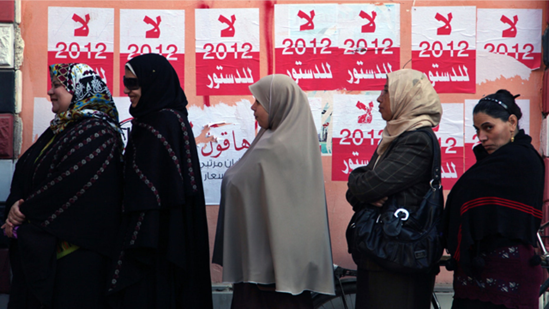 Dec. 22, 2012: Egyptian women line up outside a polling station next to stickers on a wall in Fayoum, about 62 miles south of Cairo, Egypt.