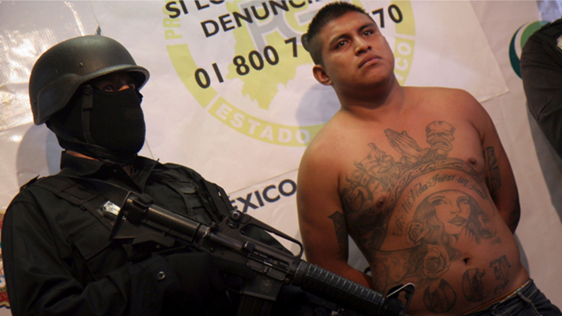 Feb. 17, 2011: A Mexico state policeman stands next to Juan Carlos Vasconcelos, 24, during a presentation to the press in Toluca, Mexico.