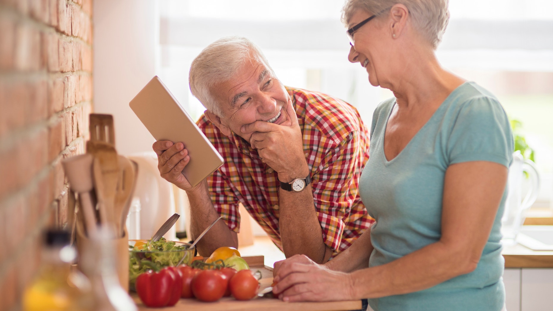 Modern senior couple spending time in the kitchen