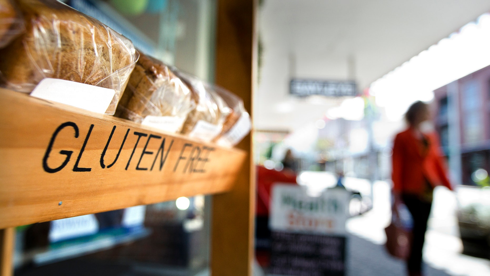 Auckland, New Zealand - October 09, 2013: Woman pass by a Gluten free grocer shop on October 09, 2013. Gluten-free food is normally seen as a diet for celiac disease, nearly 1 out of every 133 people has celiac disease.