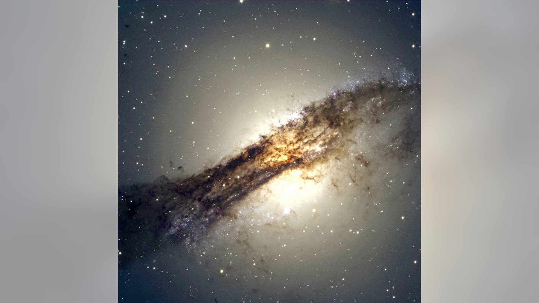 The giant elliptical galaxy Centaurus A shows a split personality because it hides a gaseous spiral at its core. When Centaurus A collided with a spiral galaxy 300 million years ago, it slurped up the spiral's gases, which formed a new spiral i