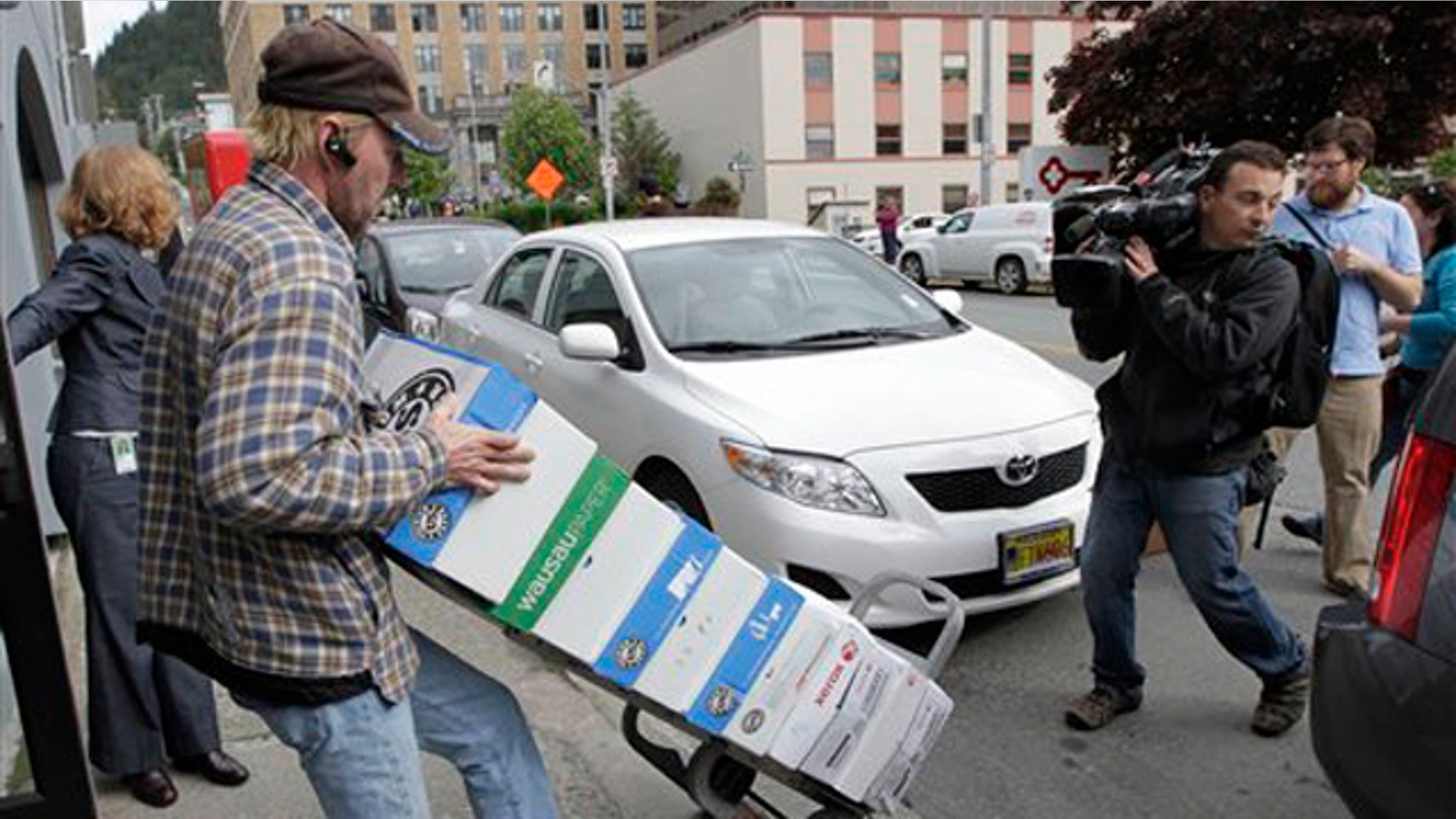 A worker rolls a cart with boxes containing thousands of pages of Sarah Palin's emails from her time as Alaska's governor June 10 in Juneau, Alaska.