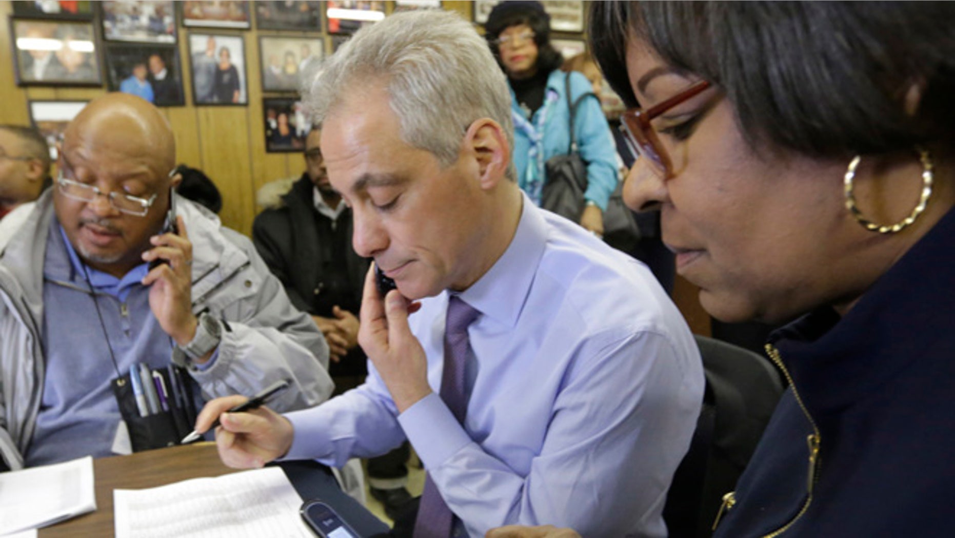 Feb. 24, 2015: Chicago Mayor Rahm Emanuel, center, and 8th ward Alderman Michelle Harris, right, join phone bank workers on election day in Chicago. (AP)