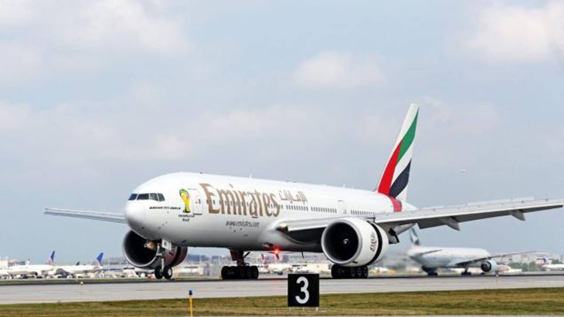 An Emirates aircraft taxis down the runway.