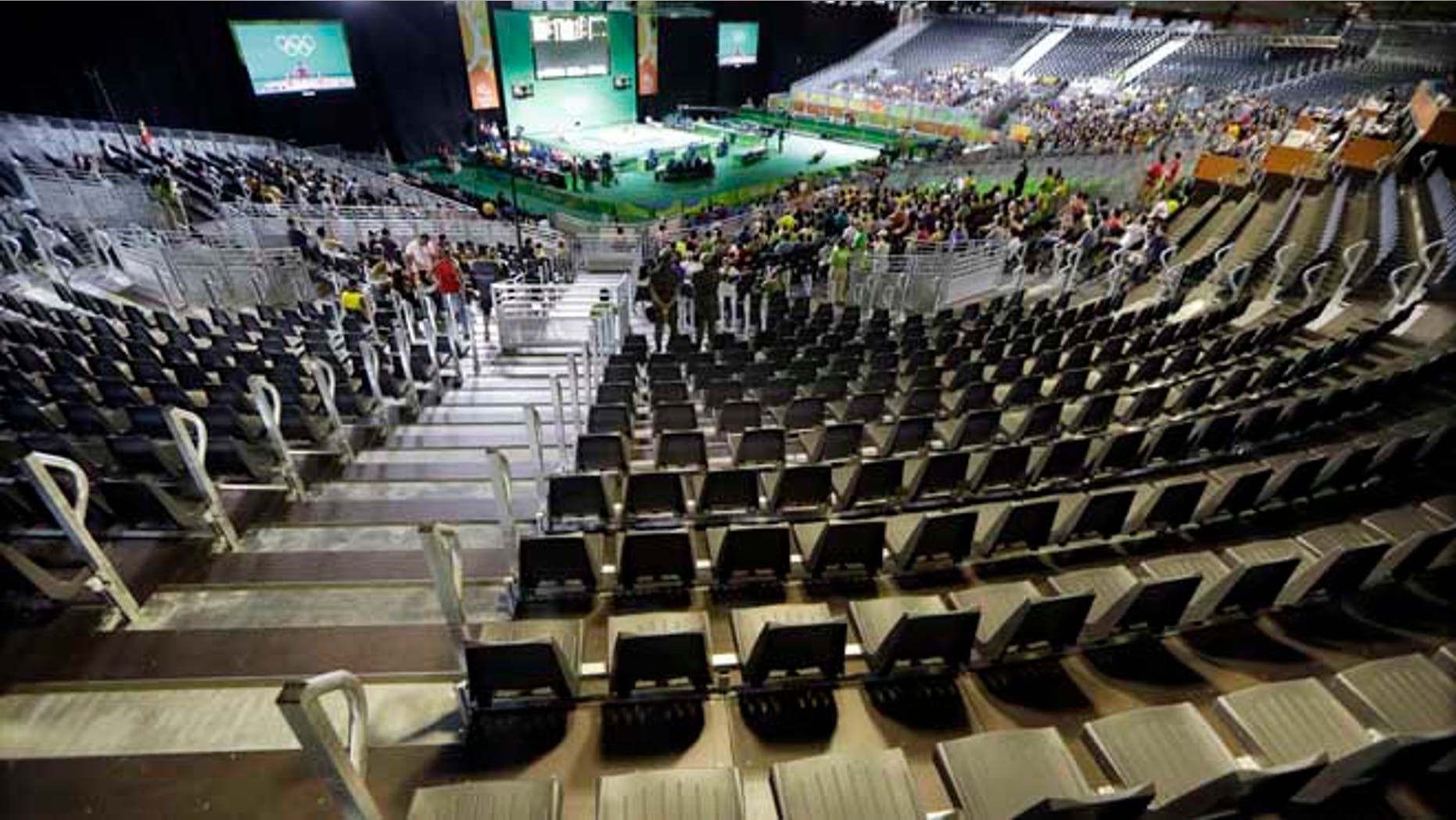 The majority of the spectator seats are empty during the men's 56kg weightlifting competition at the 2016 Summer Olympics in Rio de Janeiro, Brazil, Sunday, Aug. 7, 2016. (AP Photo/Mark Humphrey)